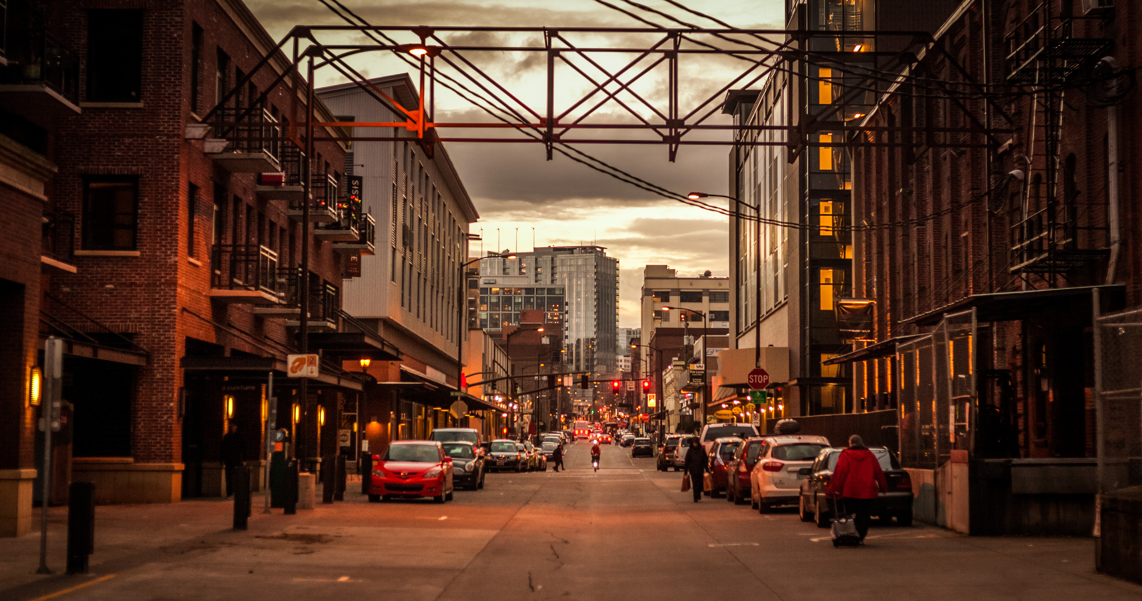 The sun sets over a busy avenue in downtown Portland