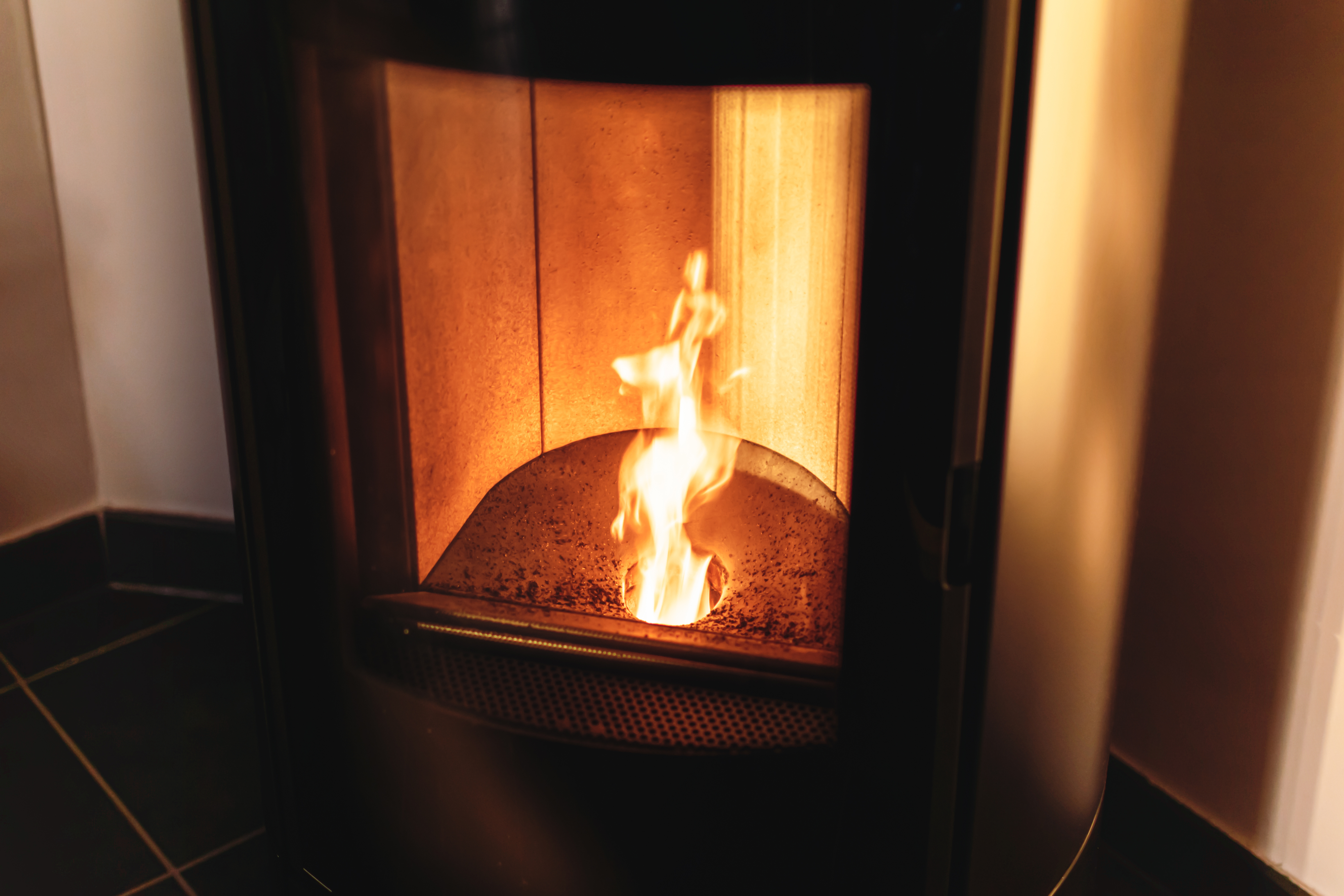 A lit fireplace with visible flames behind a glass door