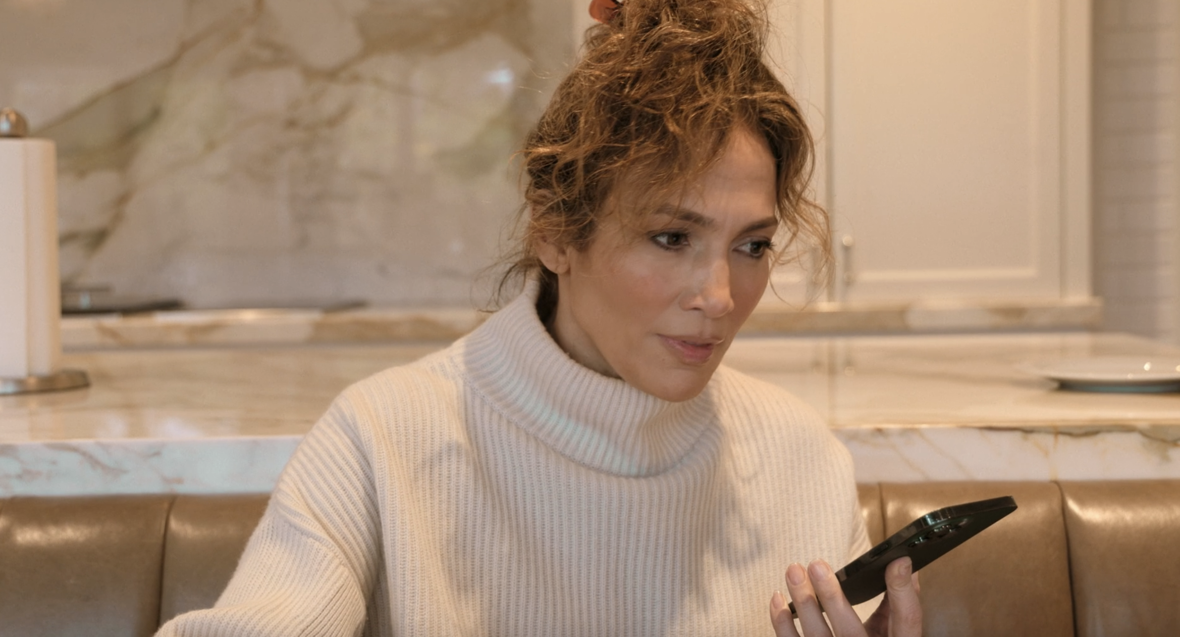 A close-up of Jennifer listening to Jane as she sits in the kitchen