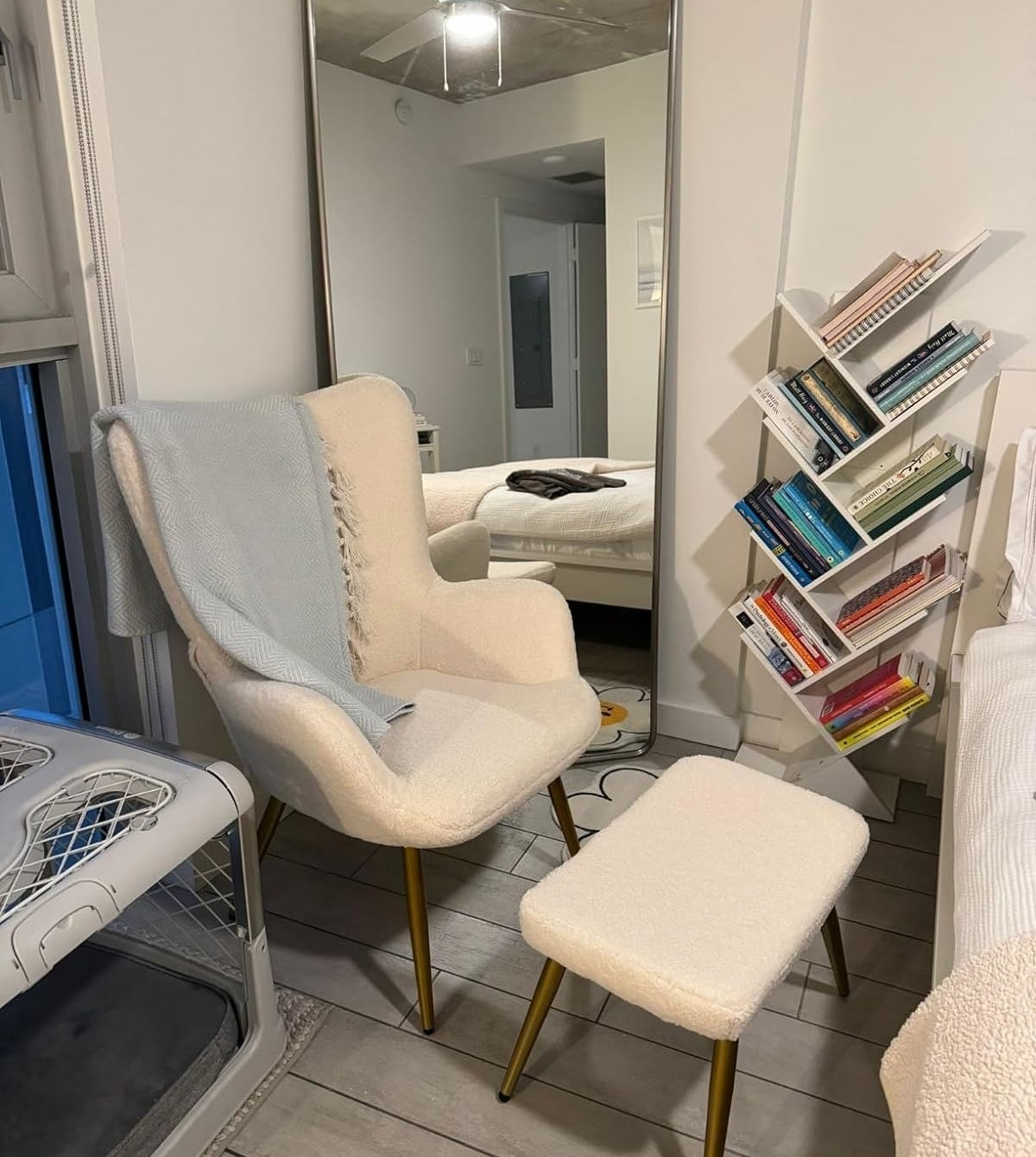 Modern style chair and footrest with gold legs in a cozy reading corner, next to a full bookshelf