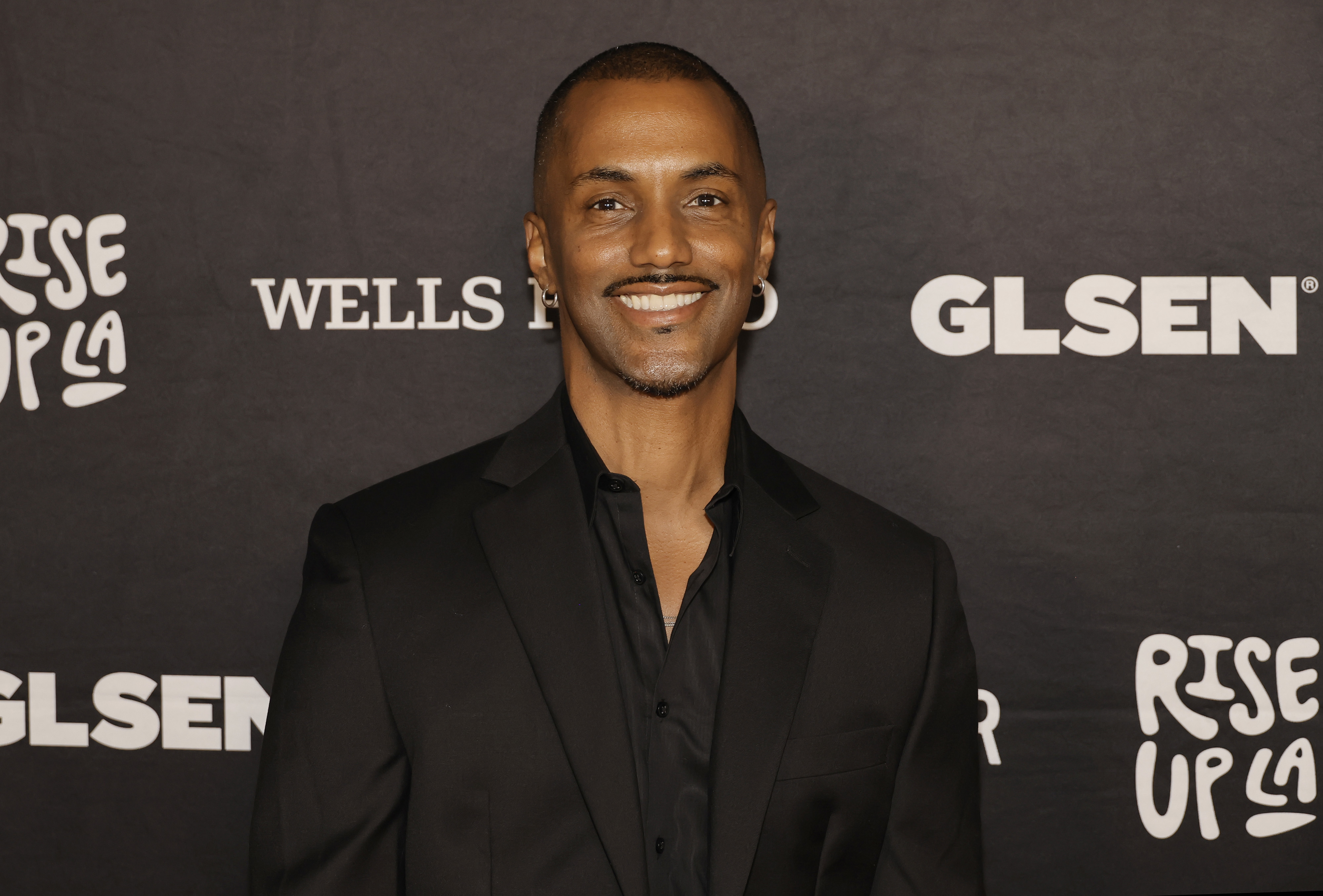 closeup of him  in a suit smiling at a GLSEN event