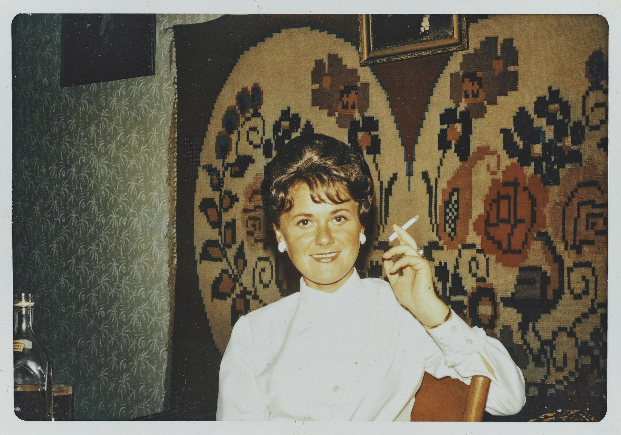 A woman is smoking a cigarette indoors