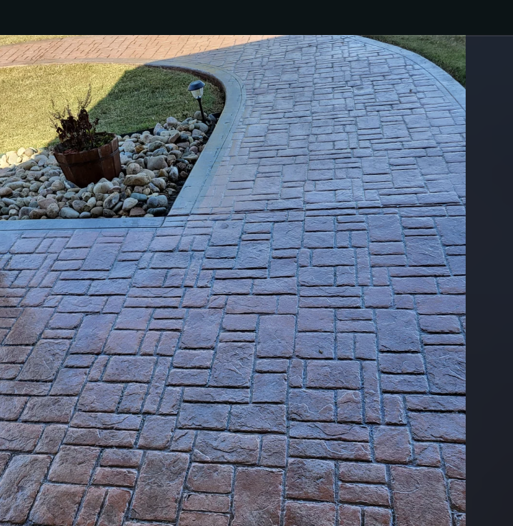 Stamped concrete pathway leading through the front yard of a house