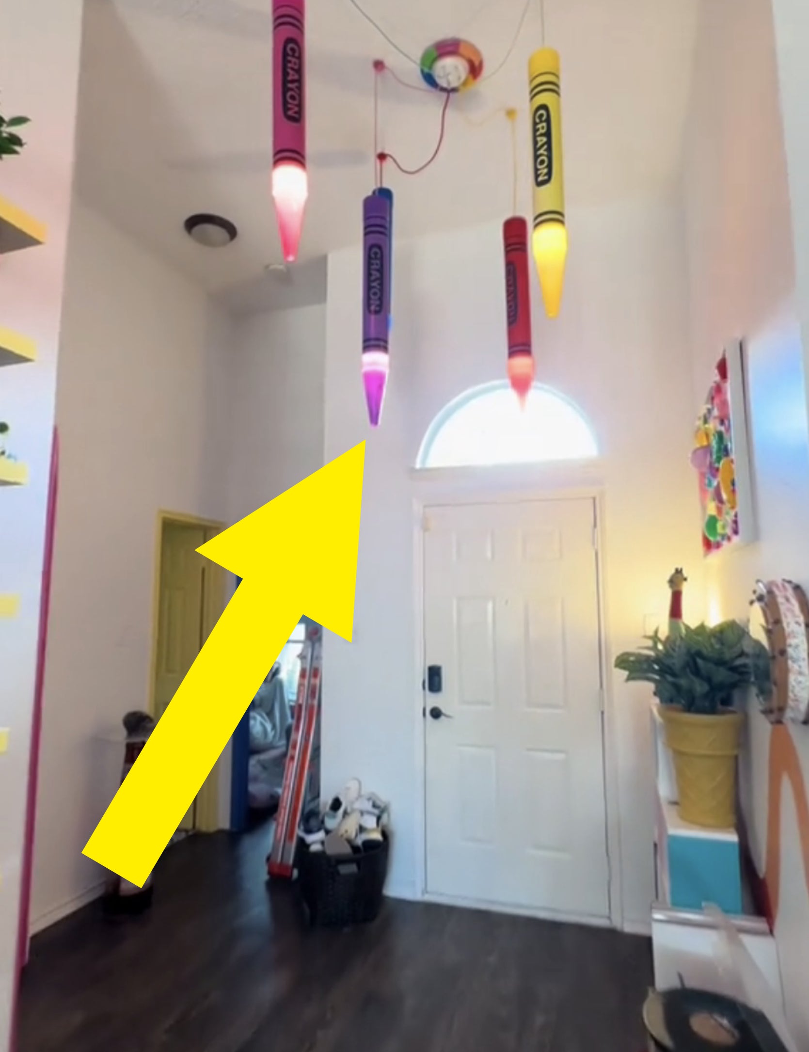 Room with crayon-shaped lights, assorted decor, and a skateboard near the entrance