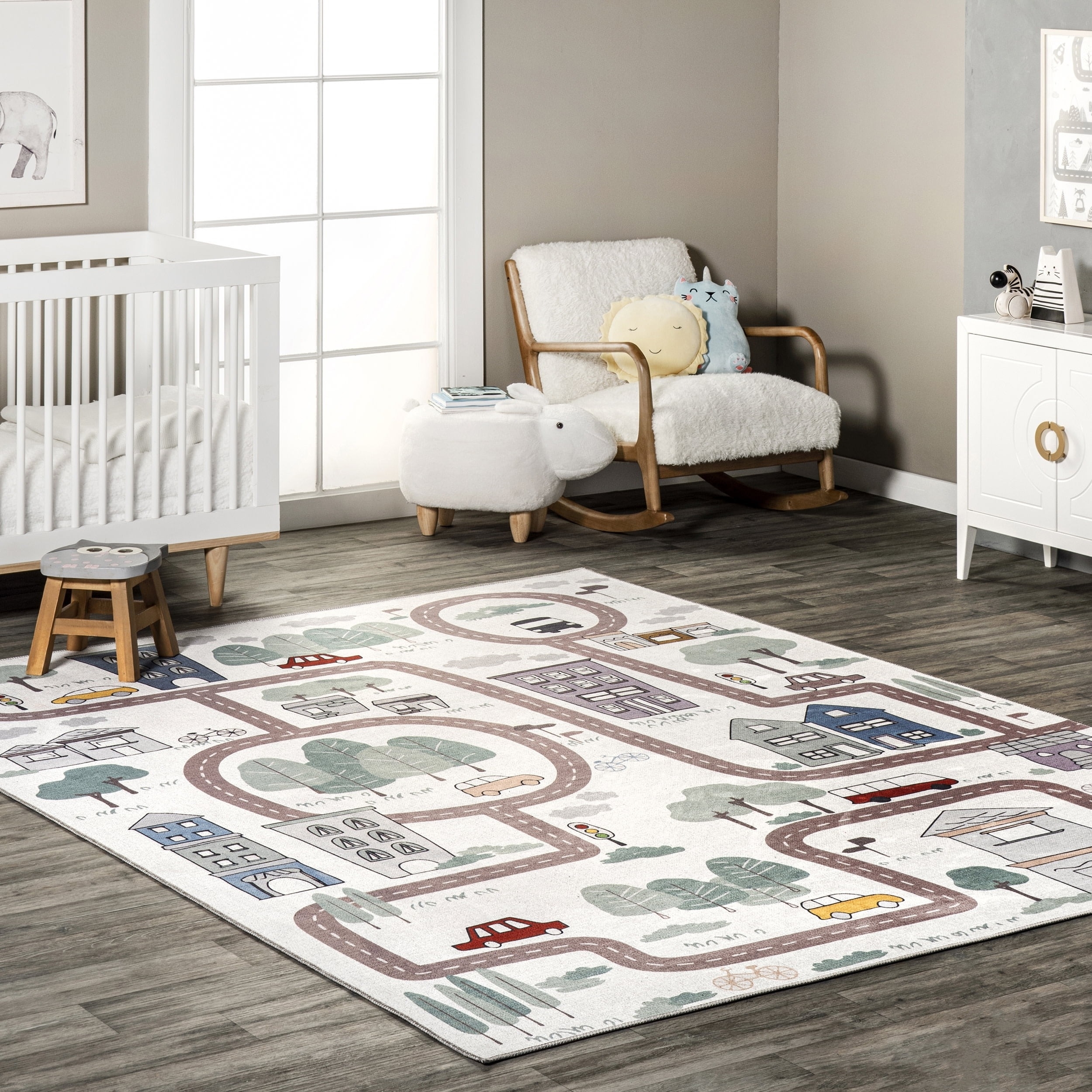 Children&#x27;s playroom with a themed rug, crib, rocking chair, and a side table with toys