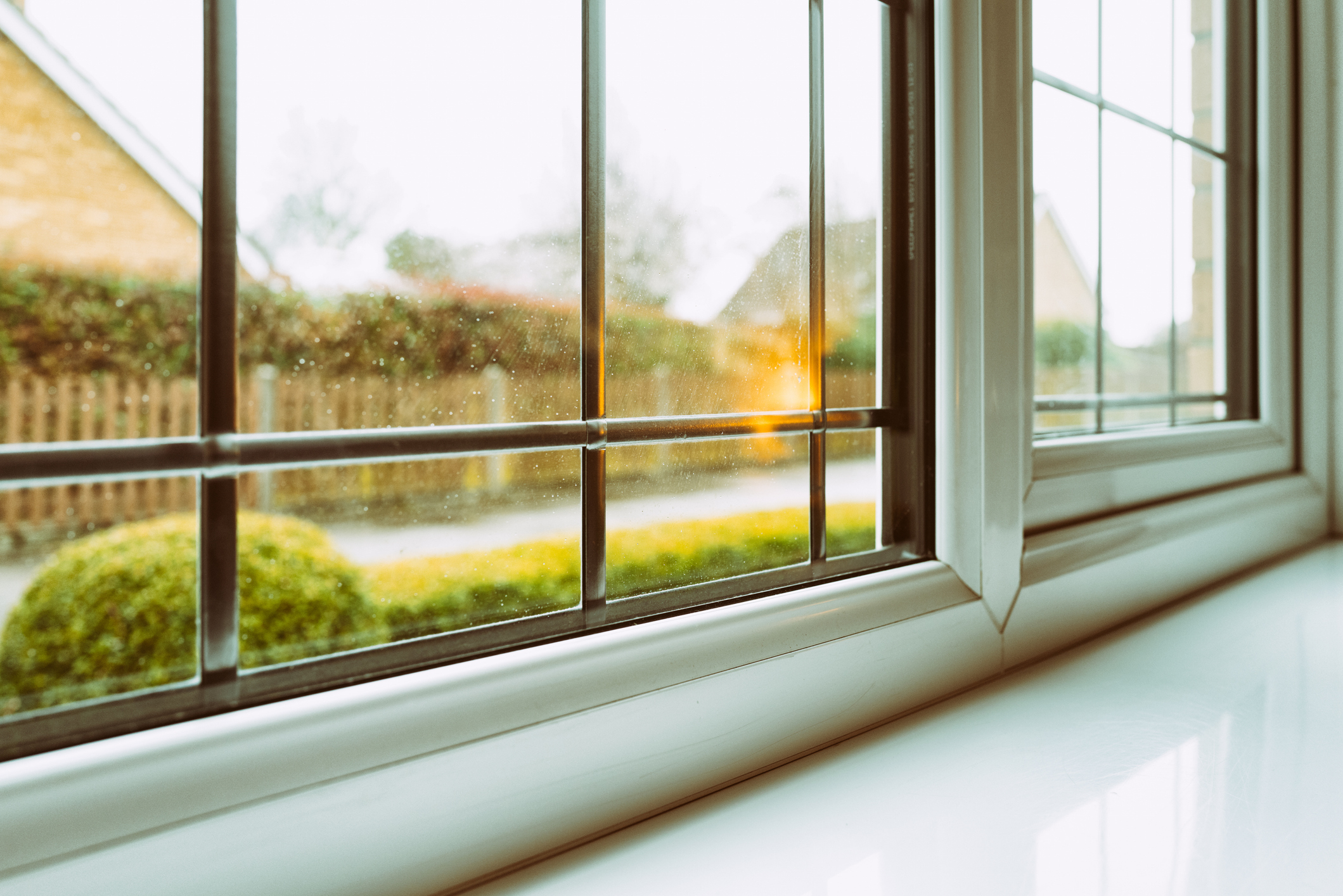 A view through a clean window showing a blurred green landscape outside