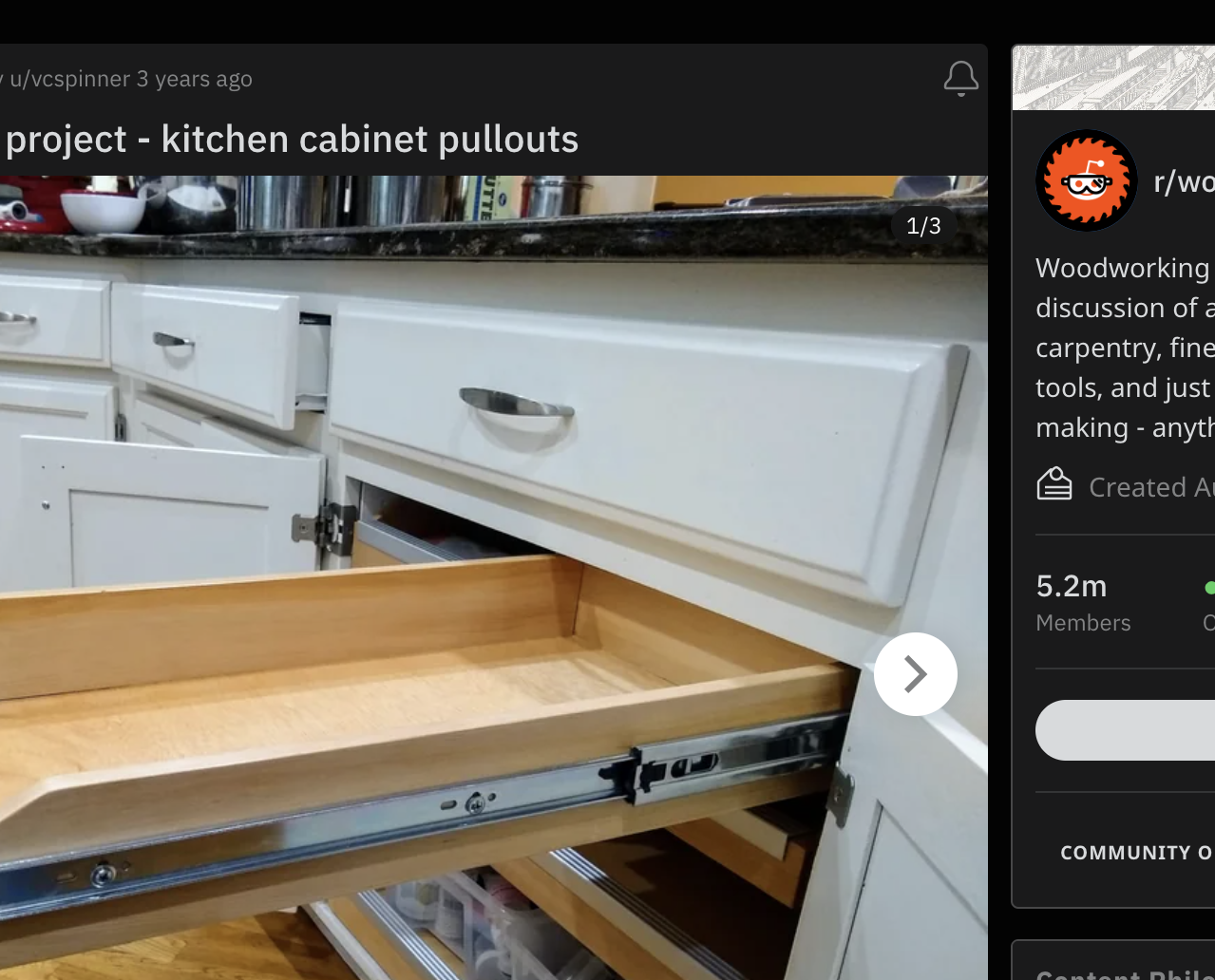 A woodworking project showing a kitchen cabinet with an open drawer featuring neatly organized utensils