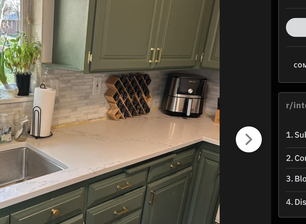 Renovated kitchen interiors with painted cabinets below green tape markings, uninstalled hardware, and a visible sink