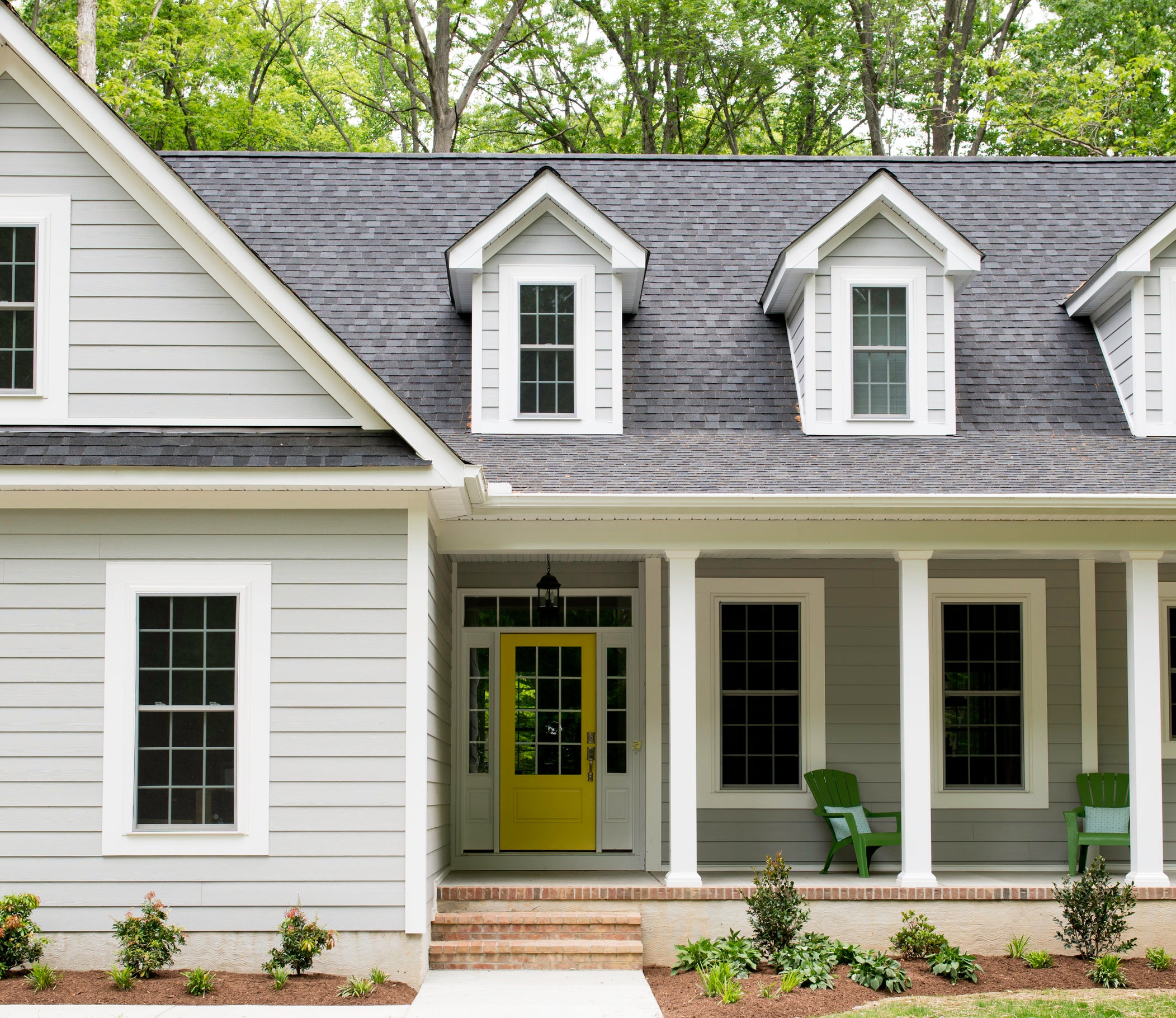 Single-story house with front porch, surrounded by trees