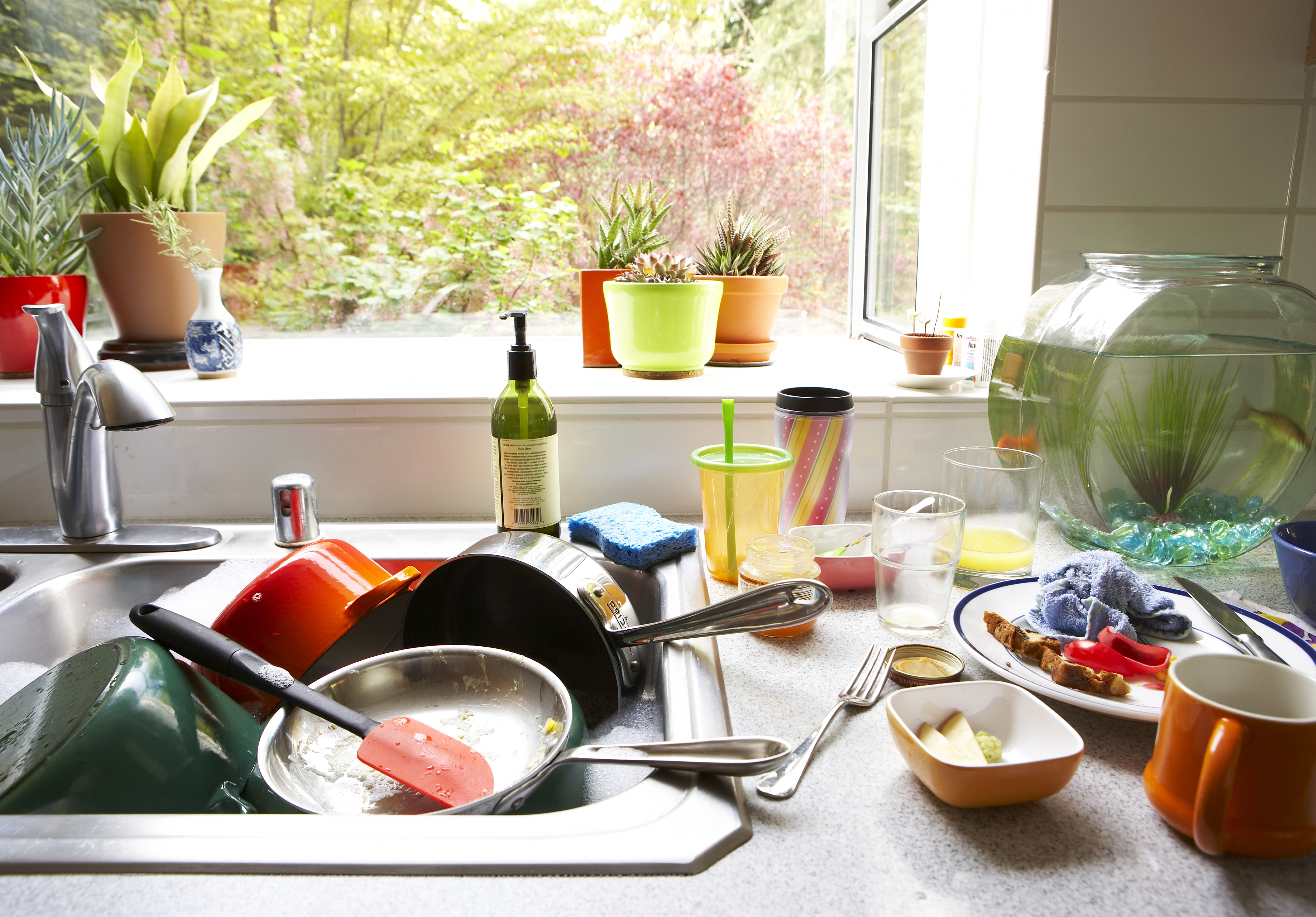 Kitchen sink and counter cluttered with unwashed dishes and utensils