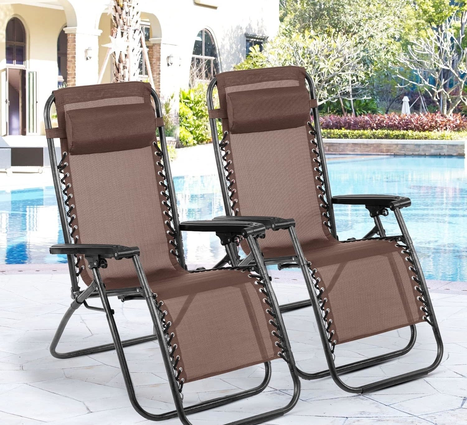 Two brown patio reclining chairs with cup holders beside a pool
