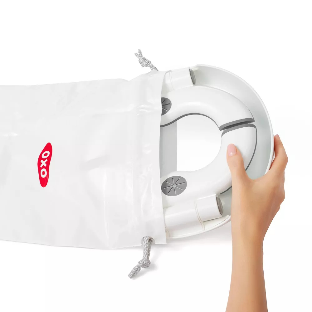 Hand inserting a white, circular device into a plastic storage bag with a red and black logo
