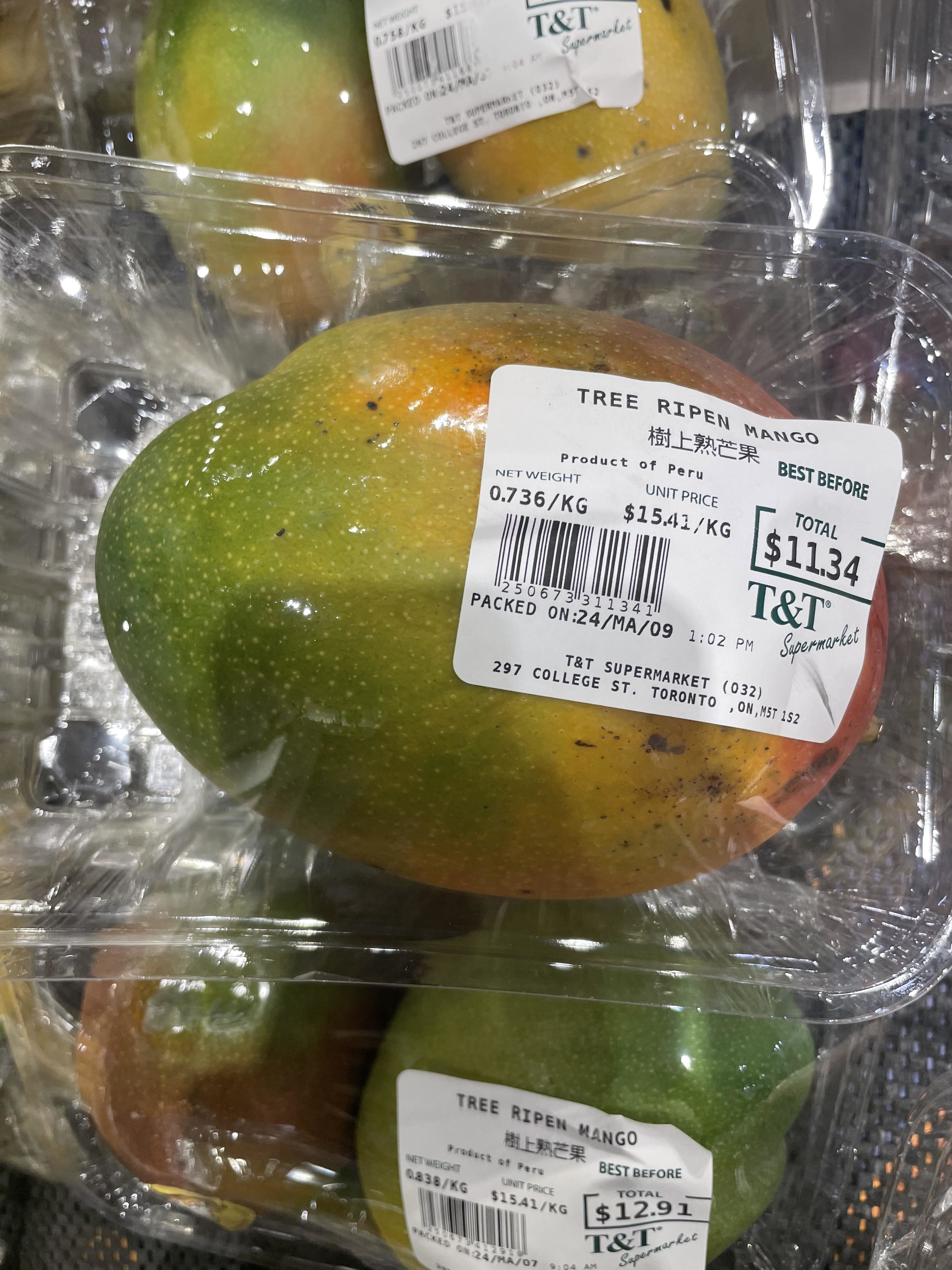 Packaged ripe mangoes with price and weight labels, on display for sale at T&amp;amp;T Supermarket