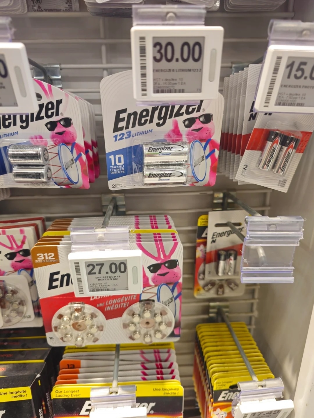 Energizer lithium batteries on store shelf with price tags, obstructed by stickers of a character with sunglasses