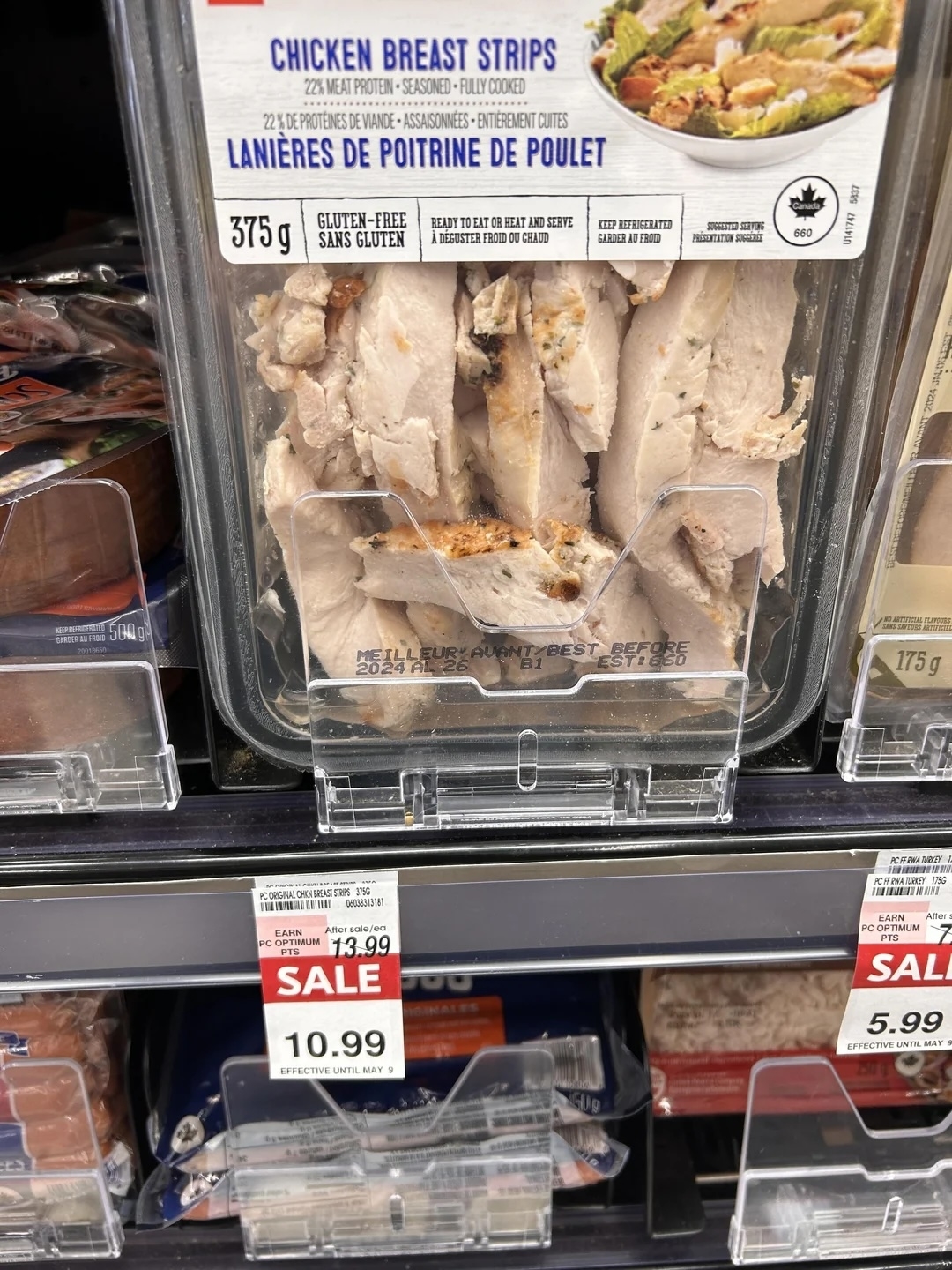 Package of gluten-free chicken breast strips on a supermarket shelf, regular price and sale price displayed