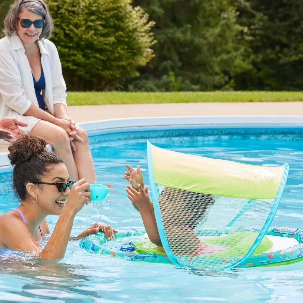 Woman and child in pool with a floating sunshade