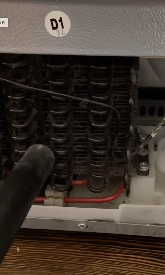 A damaged air conditioner unit with exposed coils and components