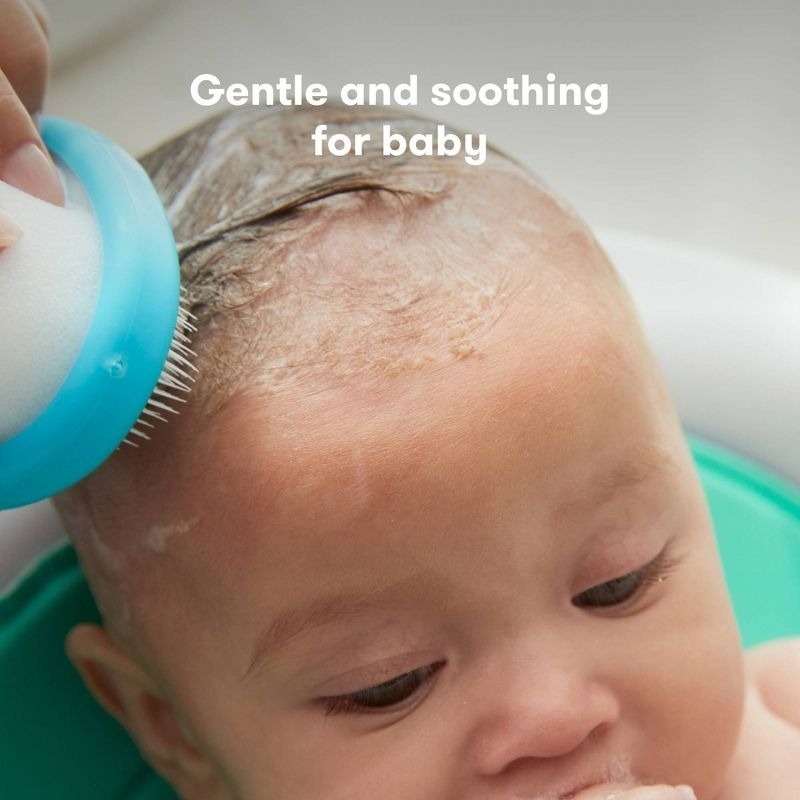 Close-up of a baby having their hair washed with a soft brush. Text reads: &quot;Gentle and soothing for baby.&quot;