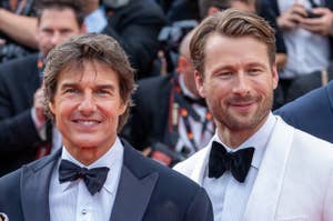 Tom Cruise and Glen Powell at a red carpet event, both wearing tuxedos with bow ties, surrounded by photographers