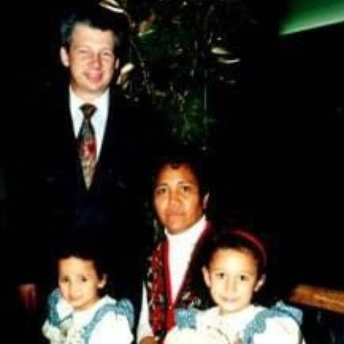 A man, a woman, and two young girls in matching outfits pose for a family photo. Names are not known