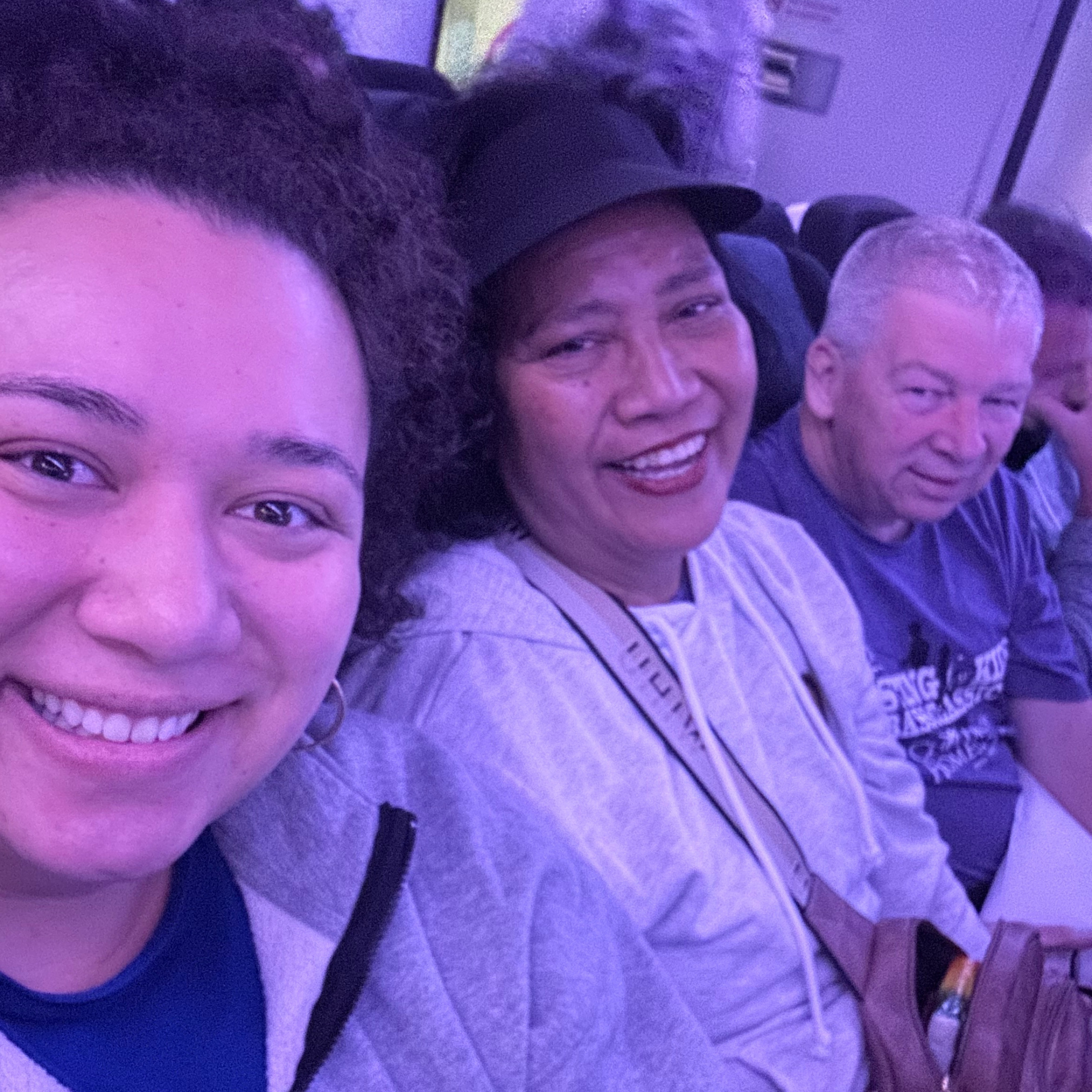 From left to right, the image shows three smiling individuals seated on an airplane: names unknown