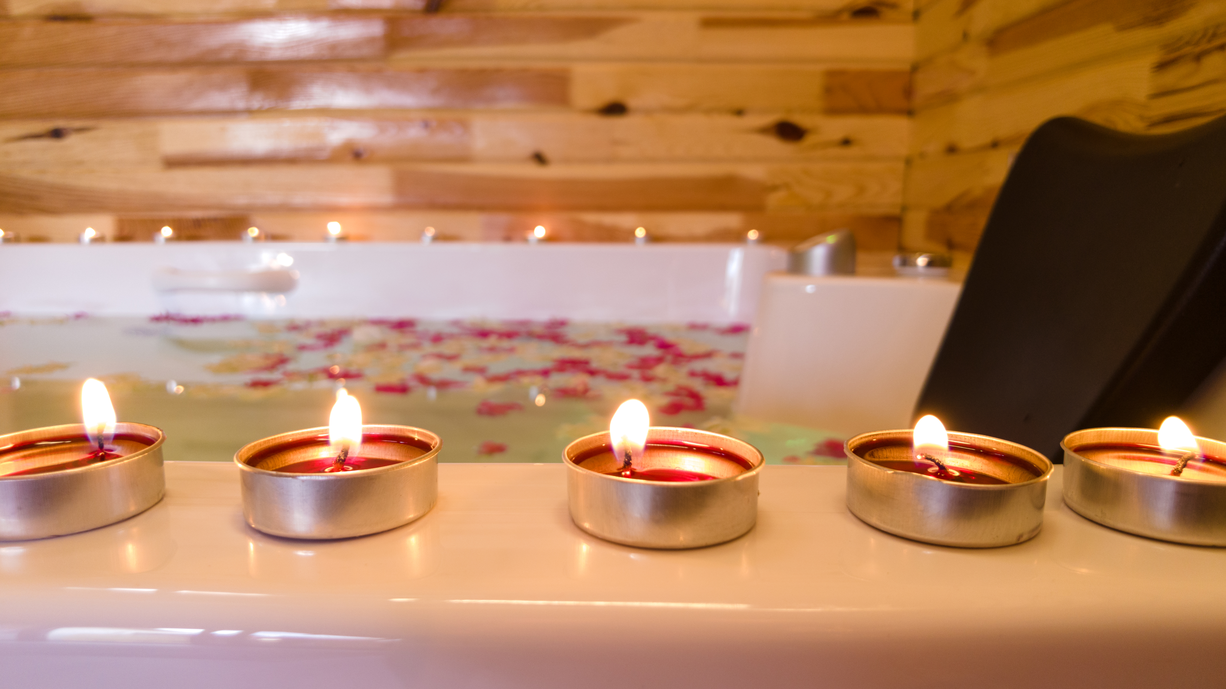 Scented candles on a bathtub edge, creating a relaxing atmosphere for a spa-like shopping article
