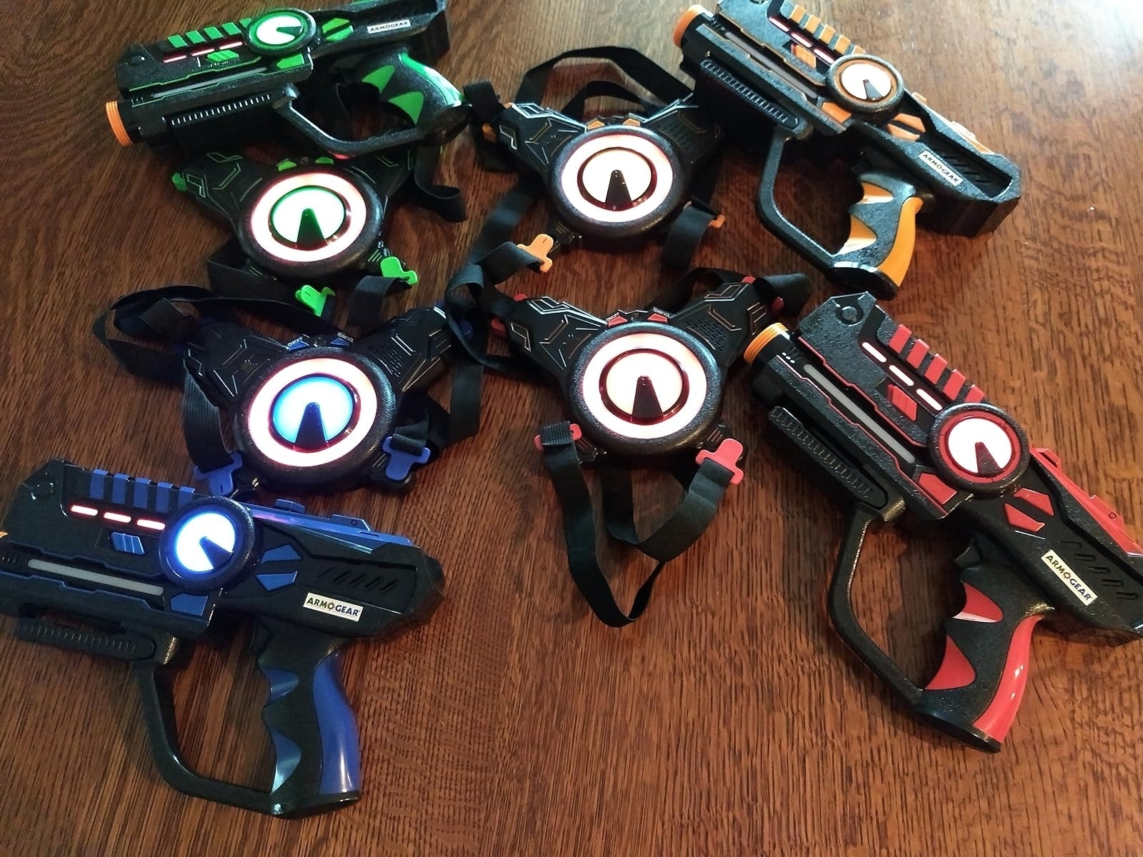 A photo of six toy laser guns in different designs and colors arranged on a table, displayed as part of a shopping article