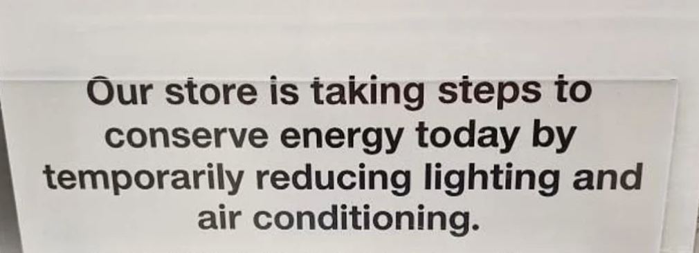 Sign reading, &quot;Our store is taking steps to conserve energy today by temporarily reducing lighting and air conditioning.&quot;