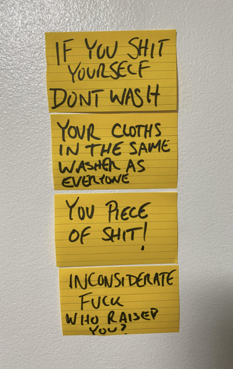 Sticky notes on a wall with handwritten text: &quot;IF YOU SHIT YOURSELF DON&#x27;T WASH YOUR CLOTHS IN THE SAME WASHER AS EVERYONE YOU PIECE OF SHIT! INCONSIDERATE FUCK WHO RAISED YOU?&quot;