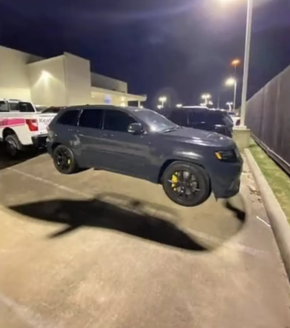 Car in a parking lot at night appears to be floating above the ground