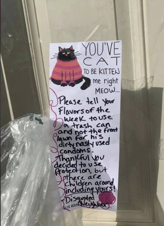 Handwritten note on a door about proper disposal of used condoms, mentioning children are around. It has a drawing of a cat in a pink sweater at the top