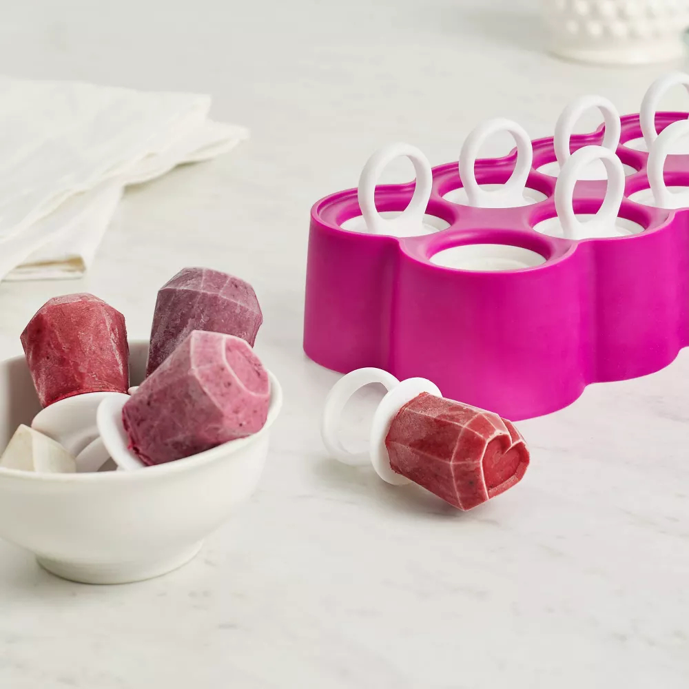 Silicone ice pop mold with gem-shaped ice pops in a bowl and on a table