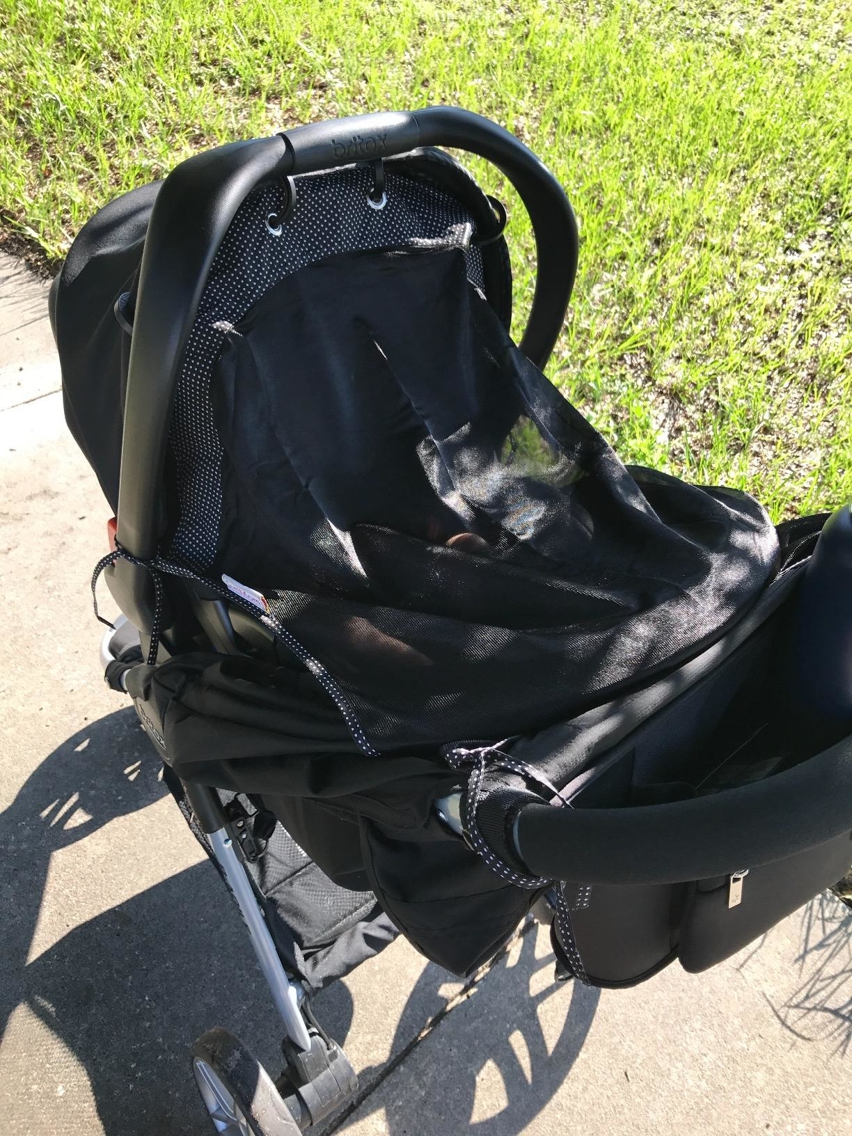 Reviewer&#x27;s photo of the sun shade attached to the front of a stroller, providing full coverage from the sun