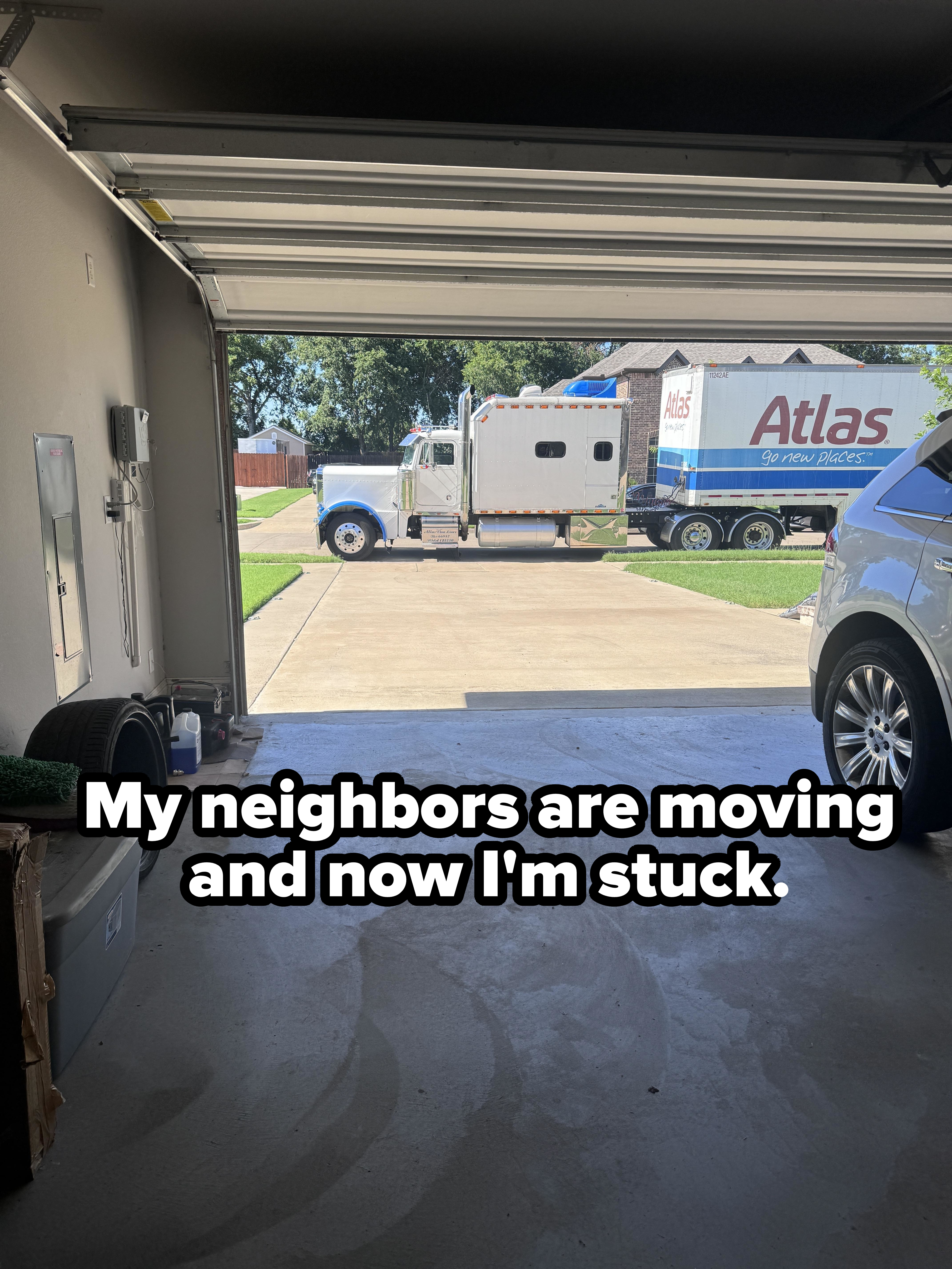 Open garage showing a moving truck labeled &quot;Atlas&quot; and a parked SUV. Nearby items include bins and household tools. No people are present