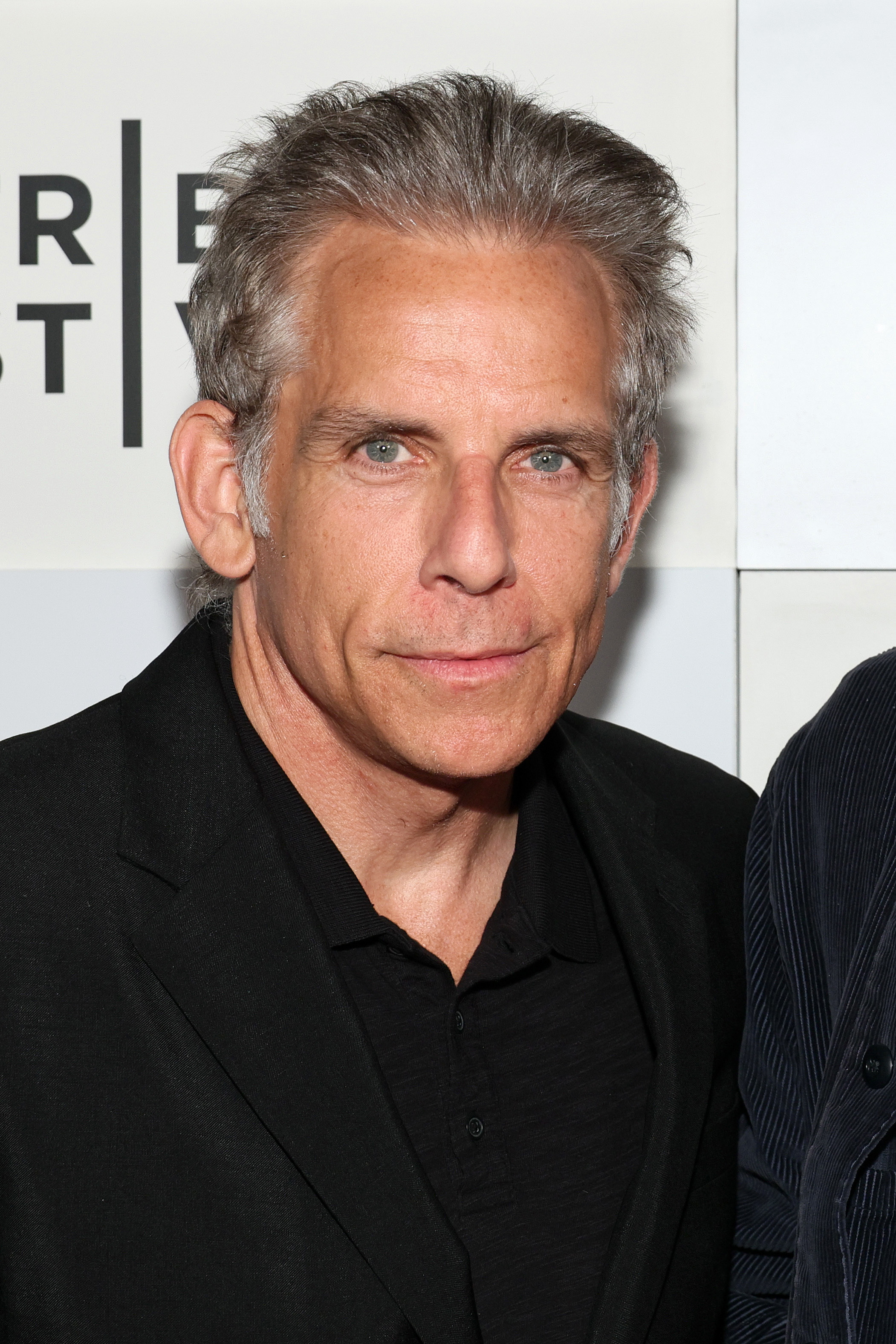 Ben Stiller wears a black suit jacket and shirt at Tribeca Festival