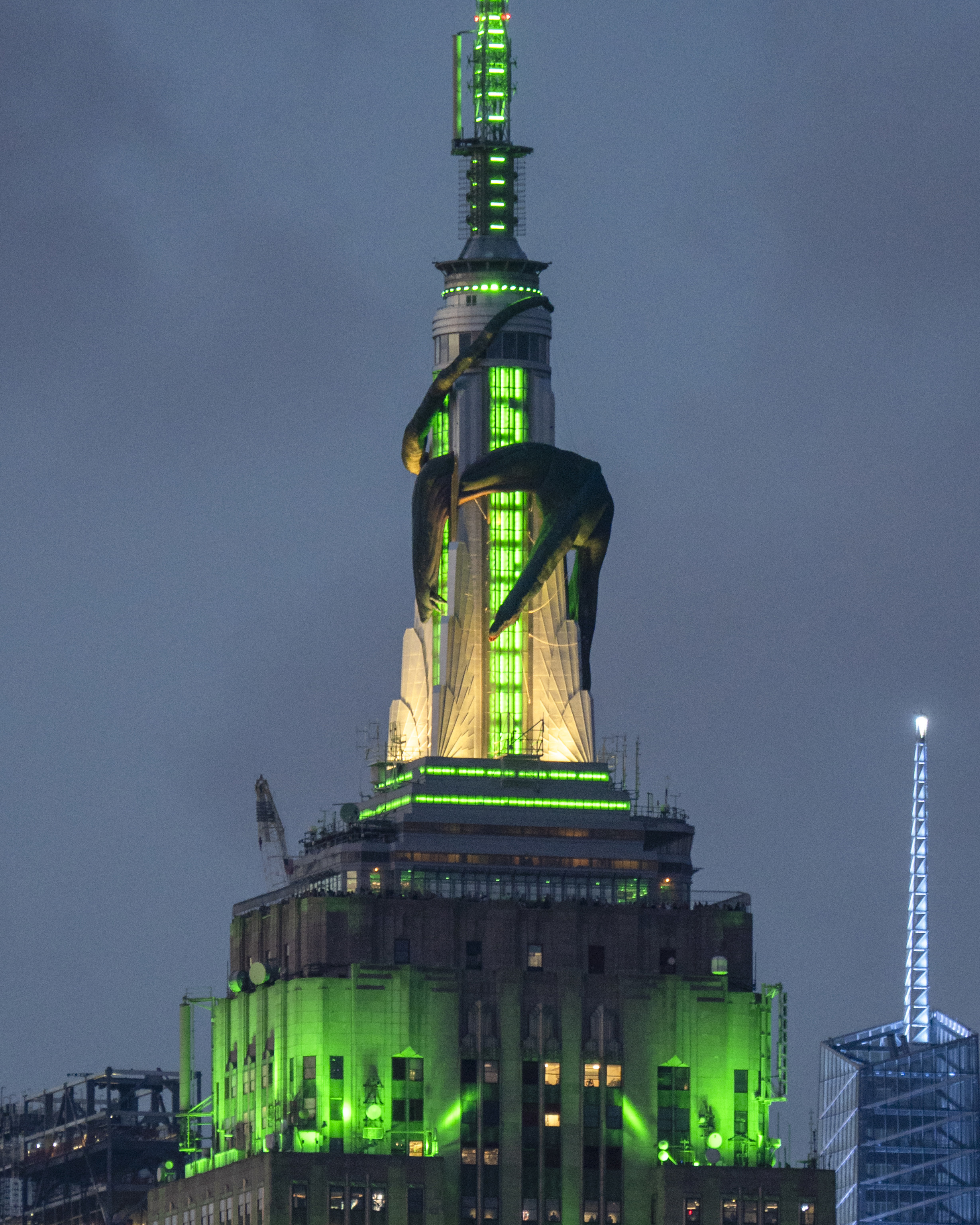 An image of the Empire State Building in New York City with a green glow and a gorilla display wrapped around the top, reminiscent of King Kong