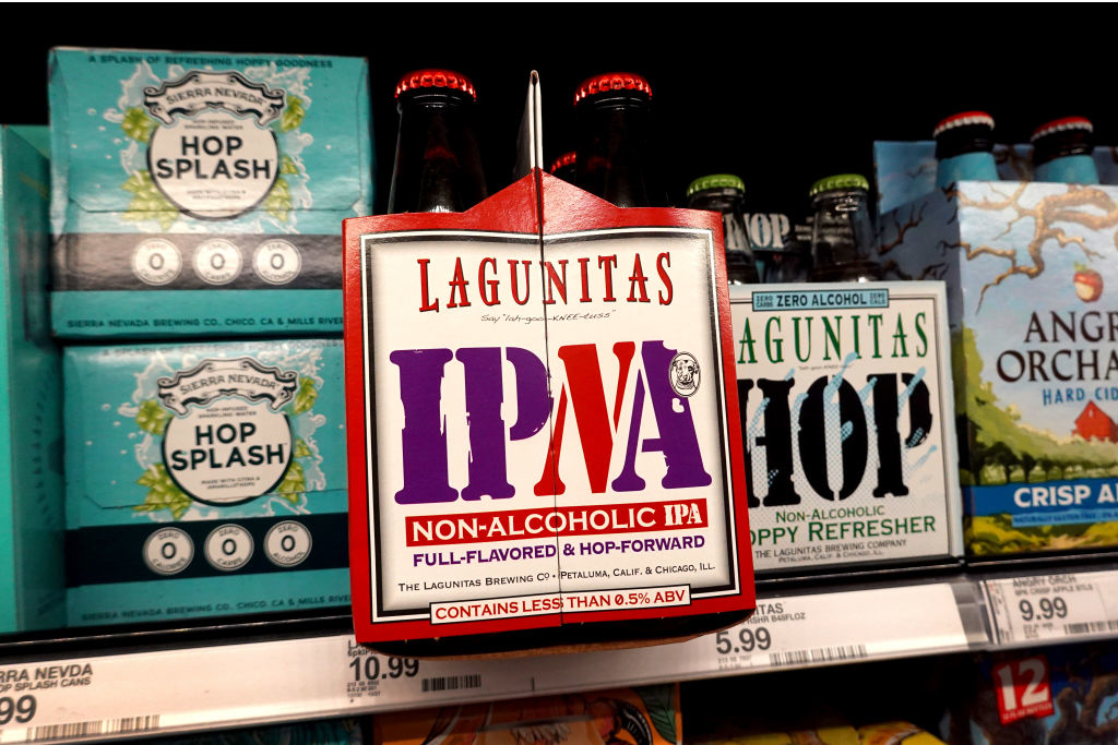 Lagunitas IPNA non-alcoholic IPA four-pack displayed on a store shelf with other Lagunitas and Sierra Nevada beverages in the background