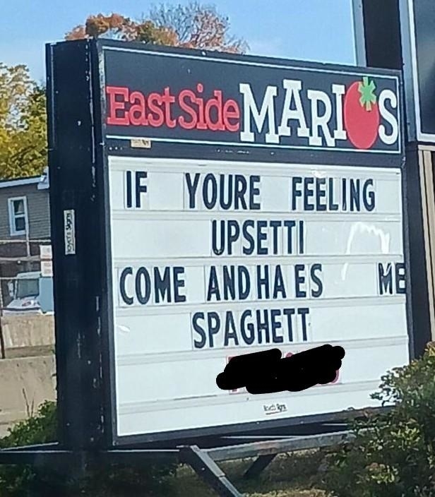 Restaurant sign reads: &quot;IF YOU&#x27;RE FEELING UPSETTI COME AND HAVE SOME SPAGHETTI.&quot; The restaurant name is East Side Mario&#x27;s. Part of the sign is censored