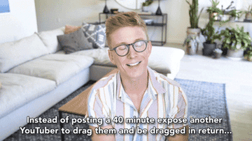 Tyler Oakley sits on a couch in a living room, smiling and wearing a striped shirt. Text: &quot;Instead of posting a 40 minute expose another YouTuber to drag them and be dragged in return...&quot;