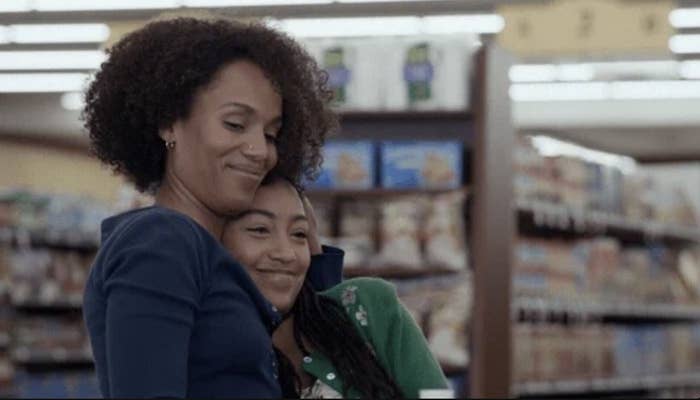 Two people, an adult woman and a young girl, warmly hugging in a grocery store aisle, appearing content and happy