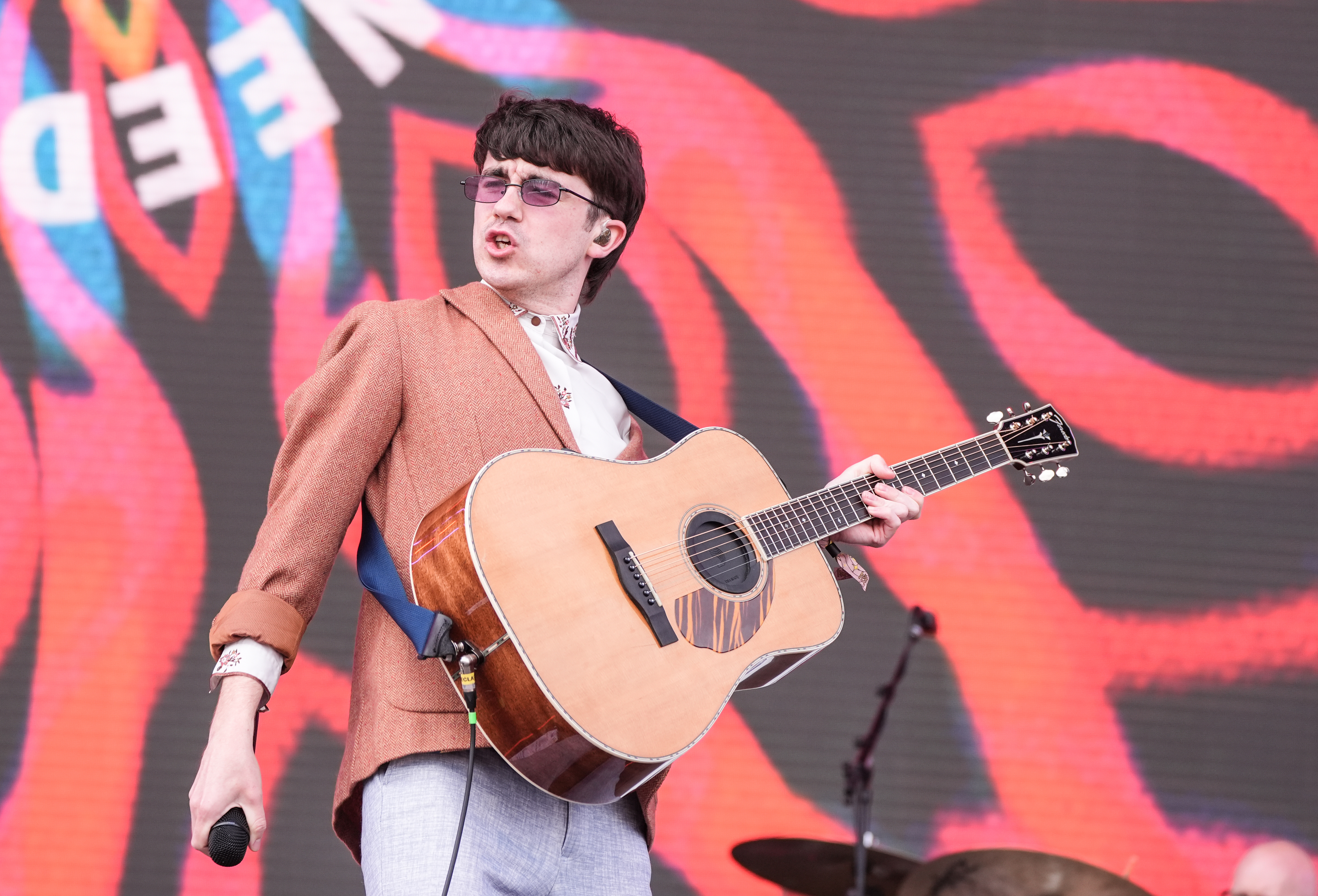 Declan McKenna onstage with a guitar