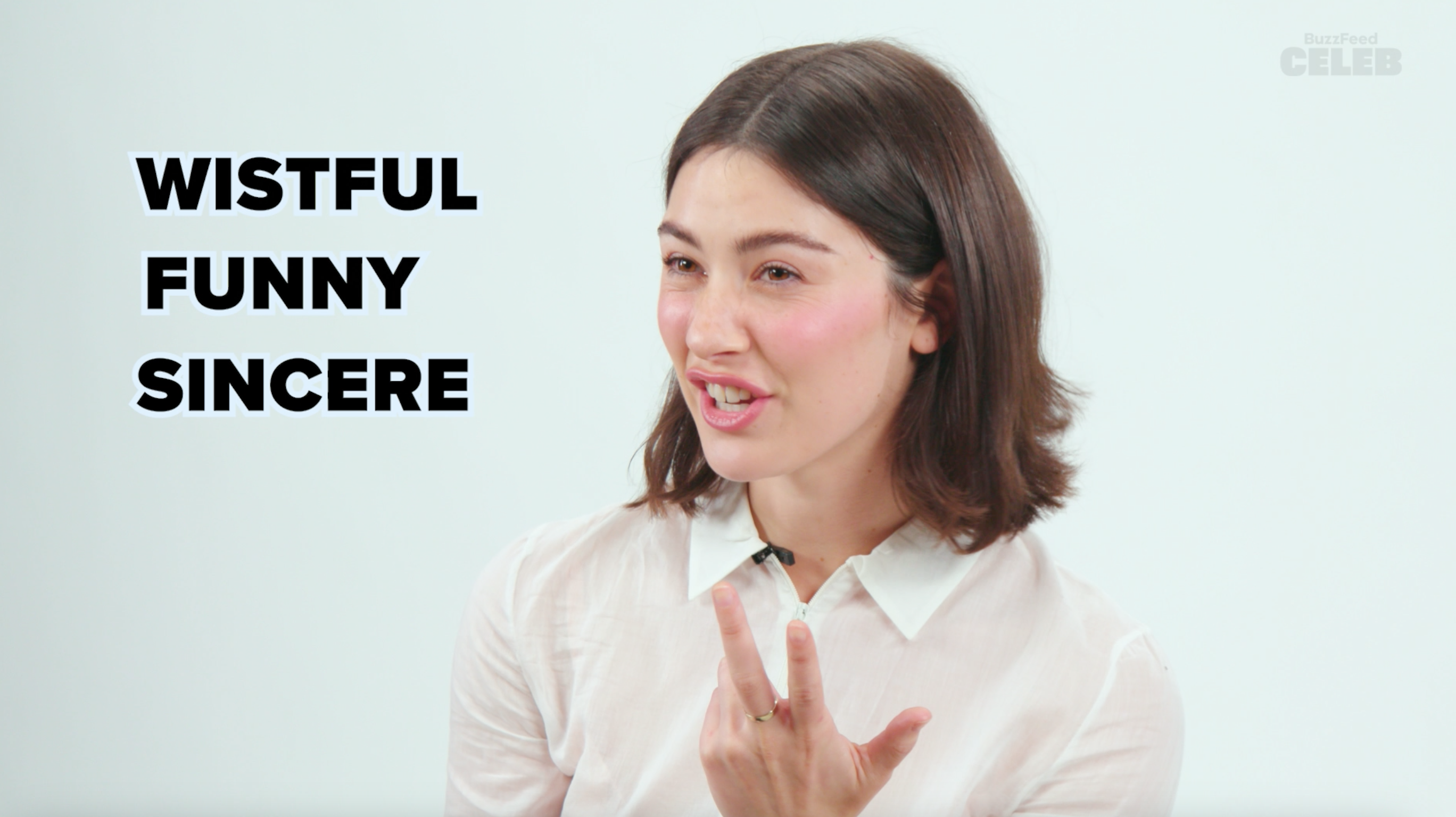 Gracie Abrams gesturing during an interview with BuzzFeed Celeb, next to the words &quot;Wistful,&quot; &quot;Funny,&quot; and &quot;Sincere.&quot;