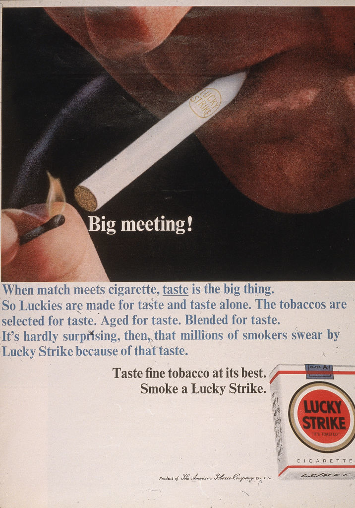 A Lucky Strike cigarette is being lit with a match. The ad headline reads &quot;Big meeting!&quot; and mentions the taste and tobacco blend quality of Lucky Strike cigarettes