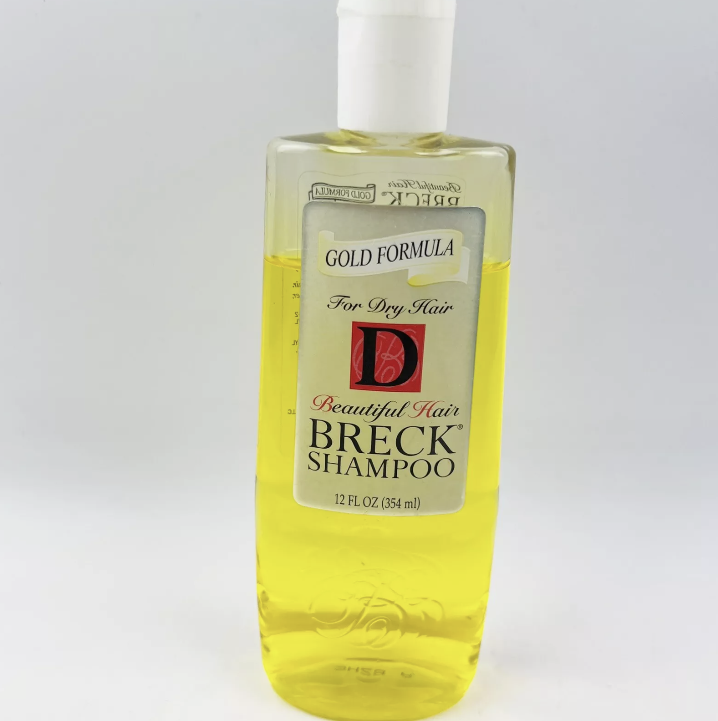 A bottle of Breck shampoo with the label reading &quot;Gold Formula, For Dry Hair, Beautiful Hair, Breck Shampoo, 12 FL OZ (354 mL)&quot;