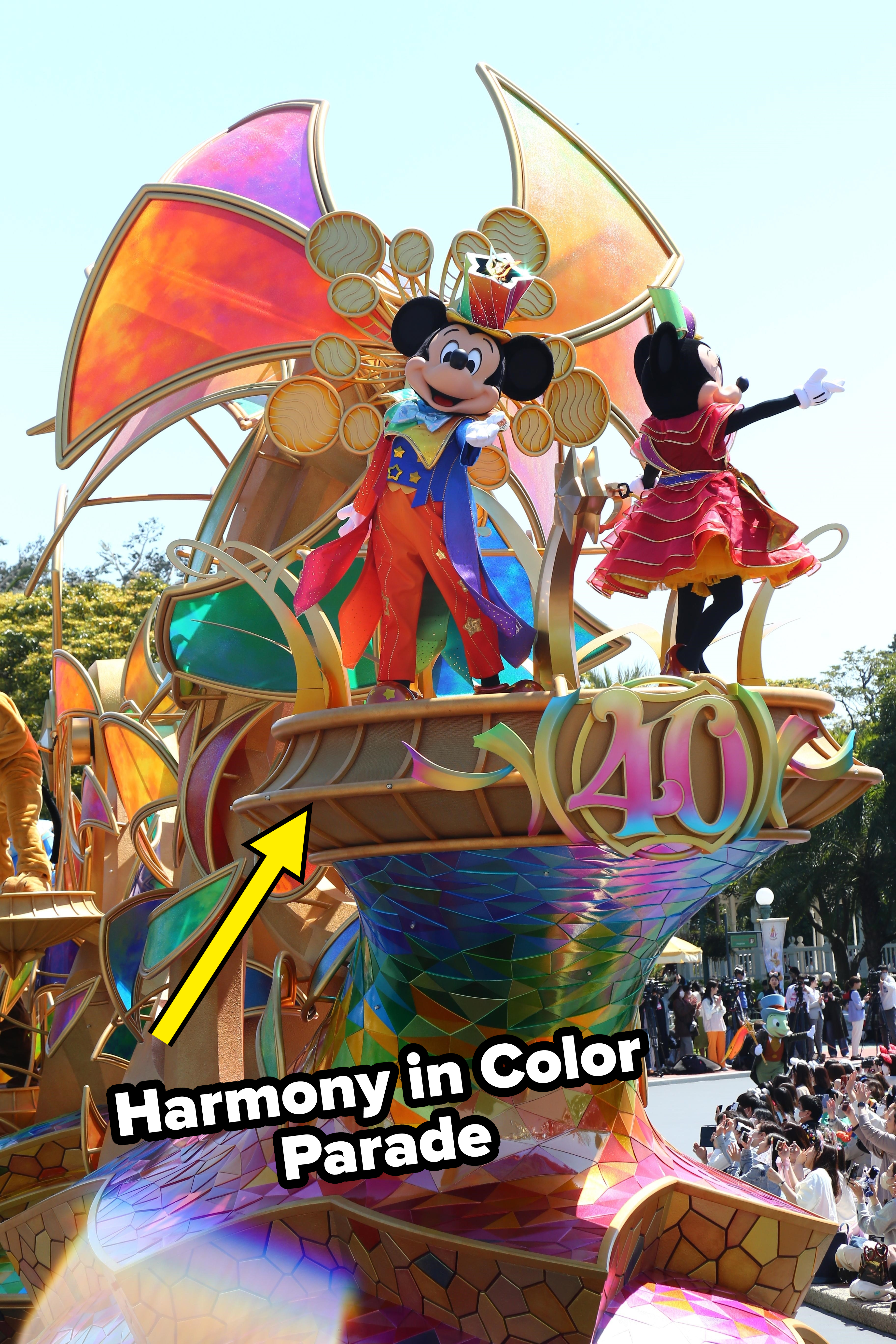 Mickey Mouse, dressed as a magician, waves atop a colorful float celebrating the 40th anniversary of Tokyo Disneyland. Minnie Mouse stands beside him in a red outfit