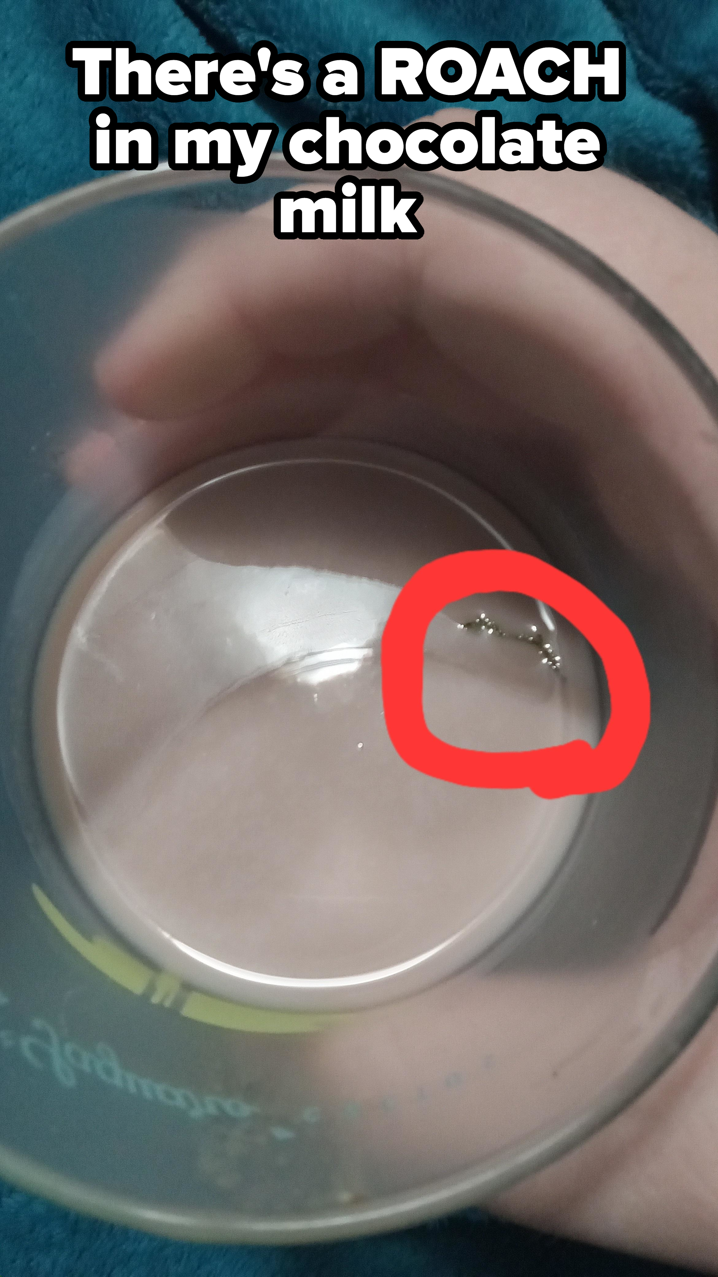 A hand holding a glass with a milk-like beverage, showing a ring inside the glass circled in red