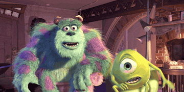 Sulley and Mike Wazowski from Monsters, Inc. look surprised, with Sulley’s mouth open and Mike covering his mouth with one hand