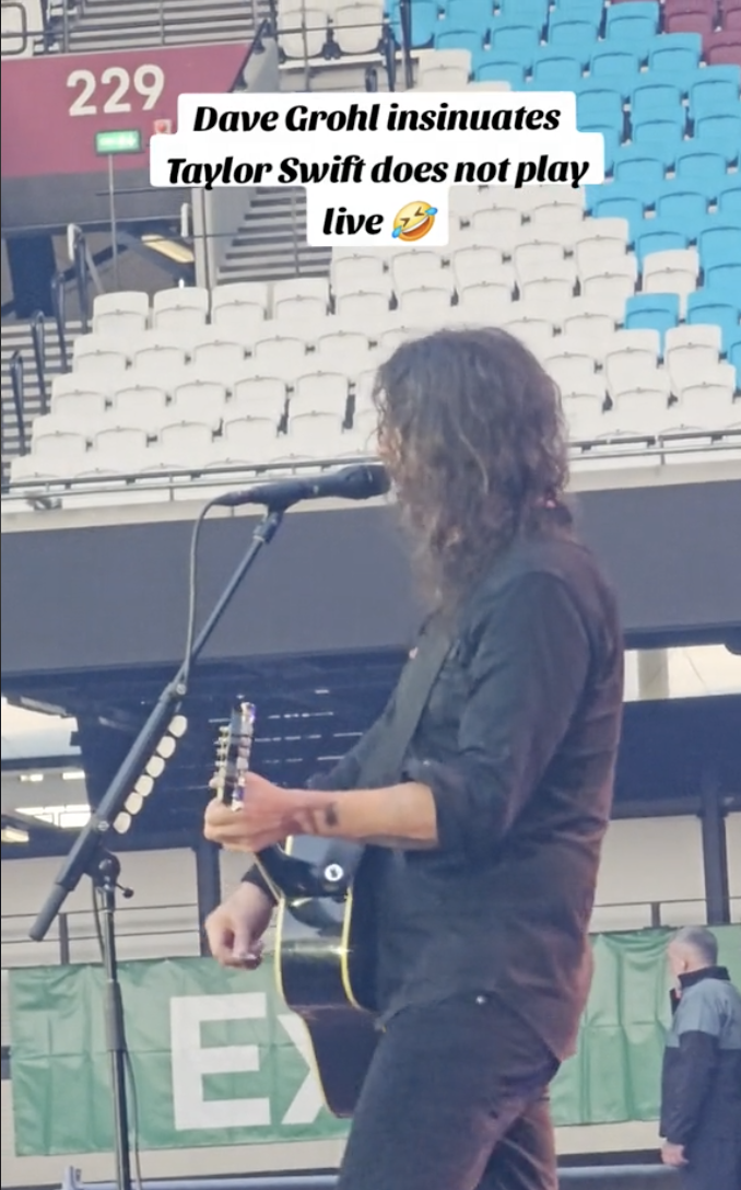 Dave Grohl playing guitar and singing into a microphone on a stage. Text reads: &quot;Dave Grohl insinuates Taylor Swift does not play live&quot; with a laughing emoji