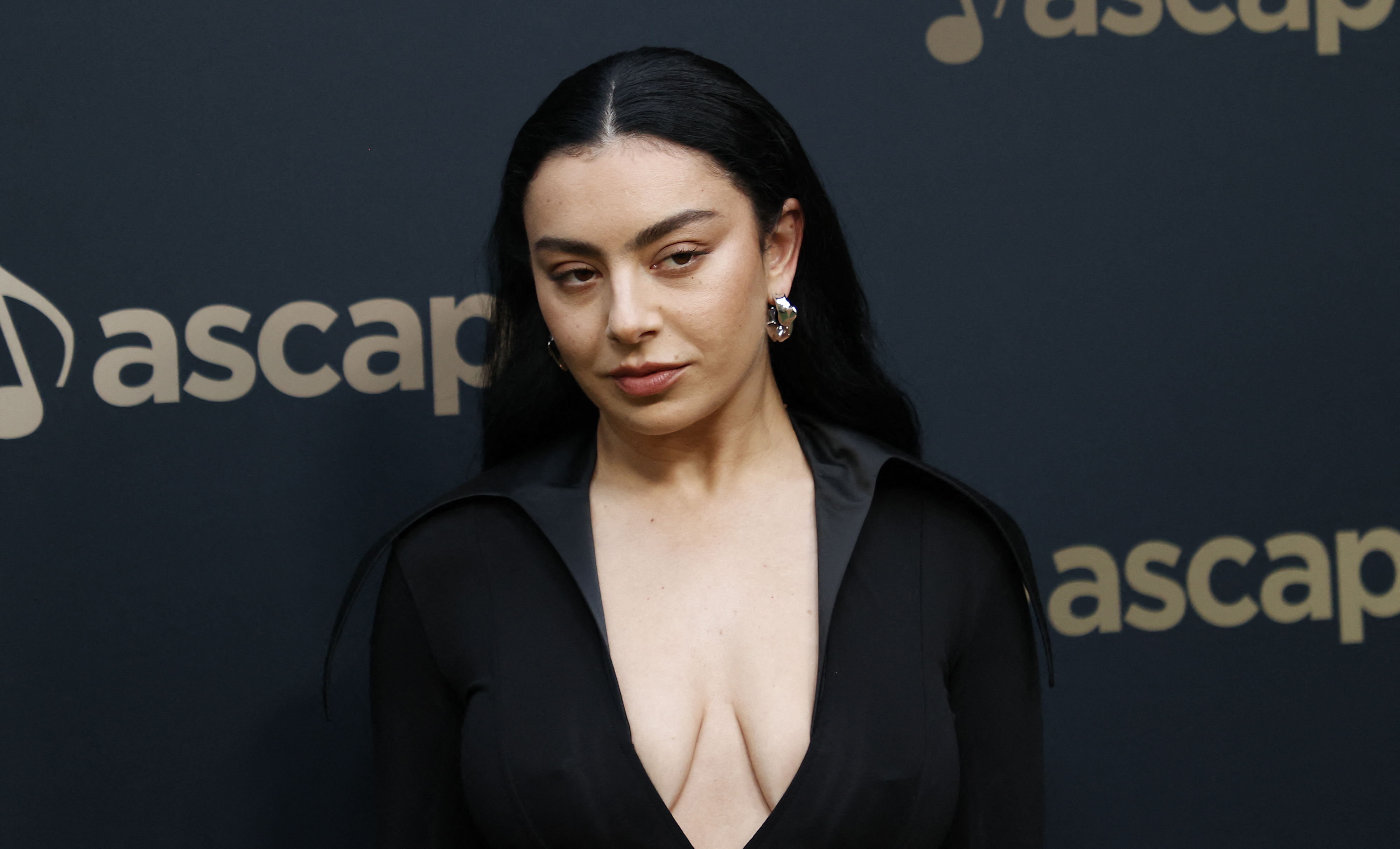 Charli XCX at an ASCAP event, wearing a plunging black dress with long sleeves