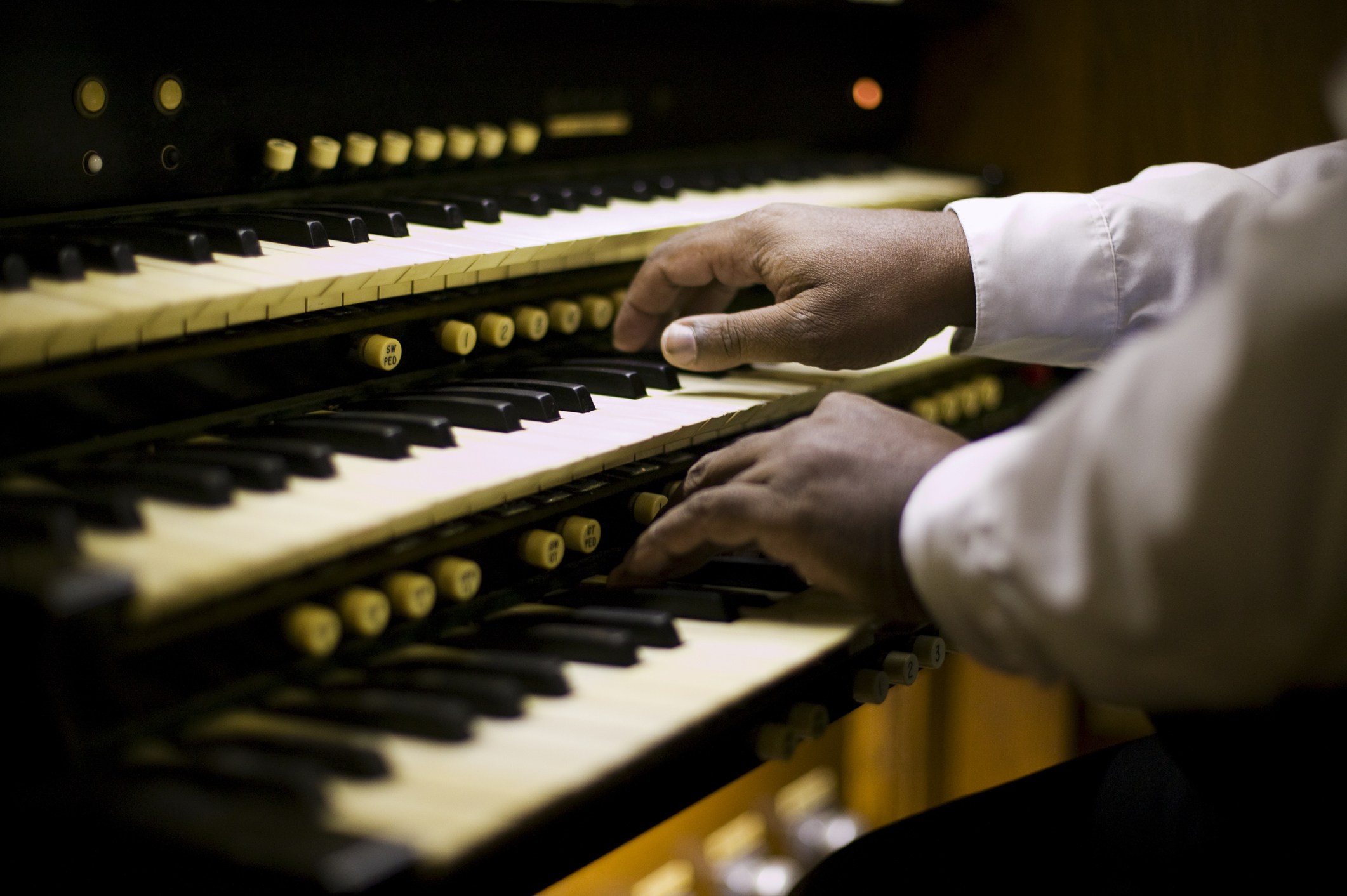 Close-up of a person&#x27;s hands playing an organ keyboard